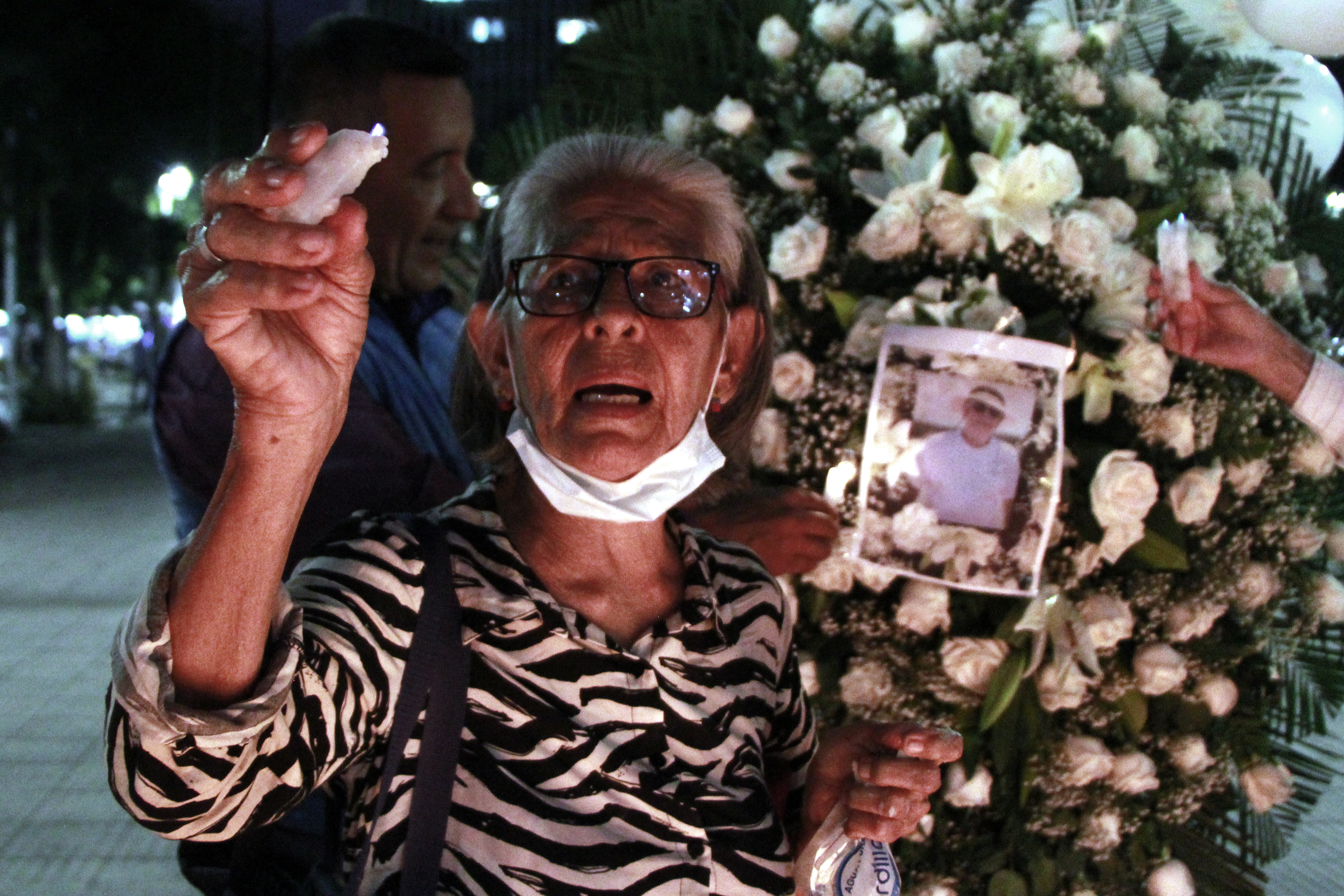 AME7907. CÚCUTA (COLOMBIA), 15/04/2024.- Una mujer enciende encienden una vela este lunes, en un acto para rechazar el asesinato del líder social Jaime Vásquez ocurrido el pasado domingo en Cúcuta (Colombia). Habitantes de la ciudad colombiana de Cúcuta, fronteriza con Venezuela, rechazaron este lunes con velas encendidas la violencia y en especial el asesinato el domingo del abogado y veedor ciudadano Jaime Vásquez, crimen que ha conmocionado a esta región. EFE/ Mario Caicedo