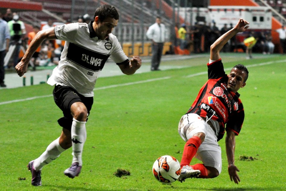 Freddy Bareiro de Olimpia desborda ante la marca de Marlon Fernández del Lara.