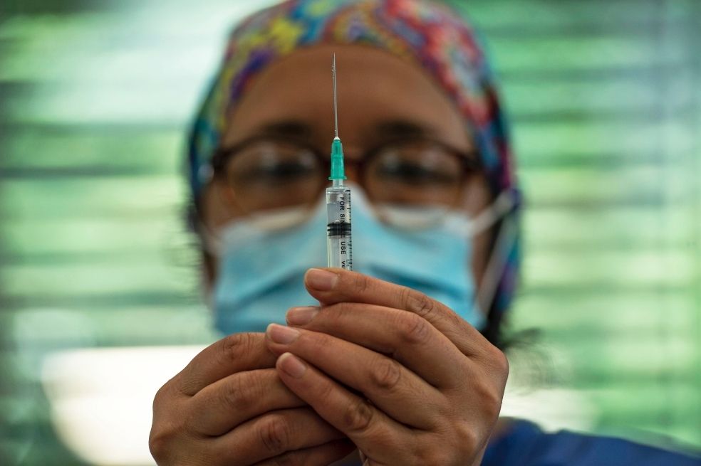 Un trabajador de la salud sostiene una jeringa con la vacuna Coronavac en un centro de vacunación en el Parque Bicentenario, en Santiago.