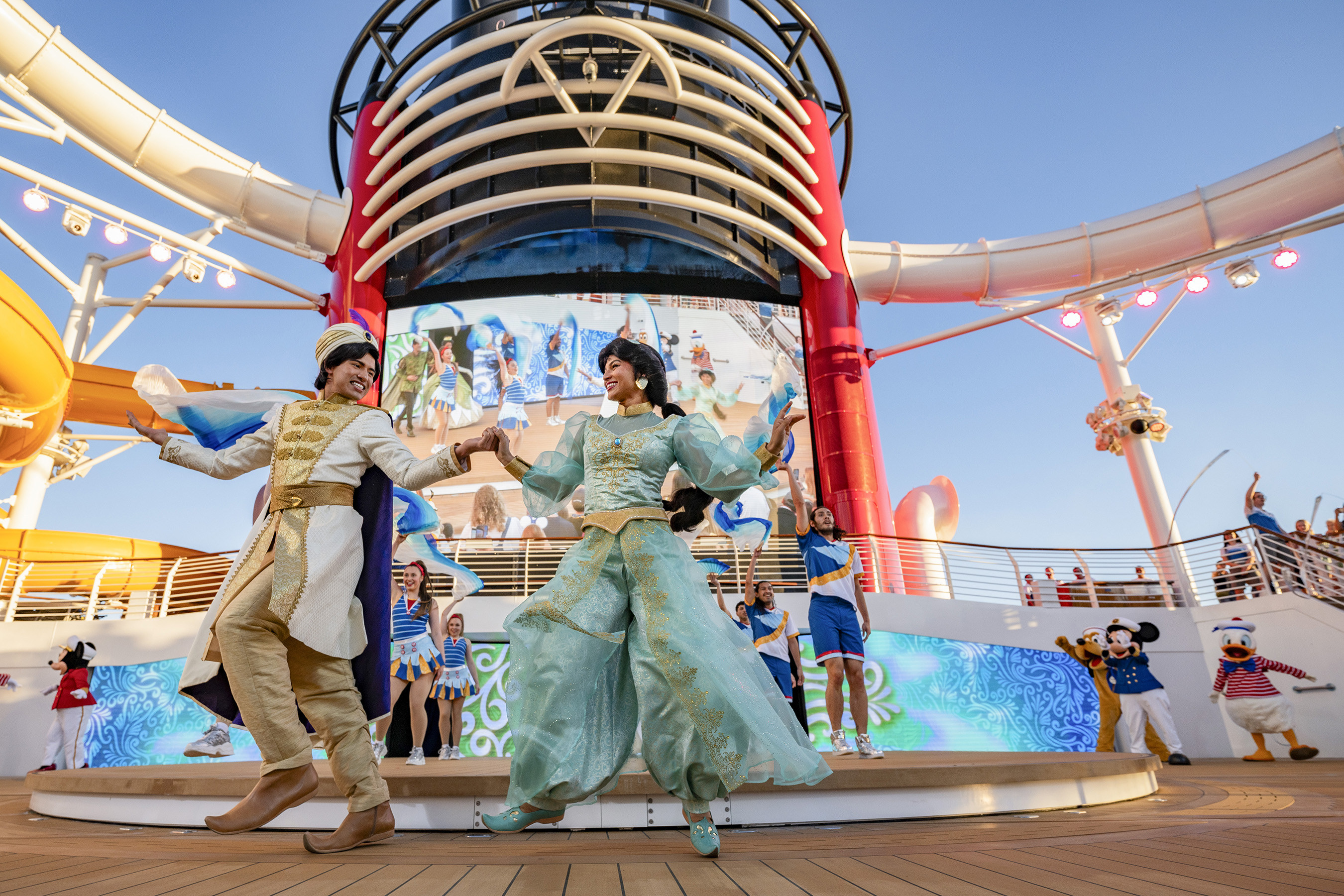 Los personajes de Disney se unen a los huéspedes en las cubiertas superiores para una fiesta de celebración que da inicio a cada viaje en el Tesoro de Disney.