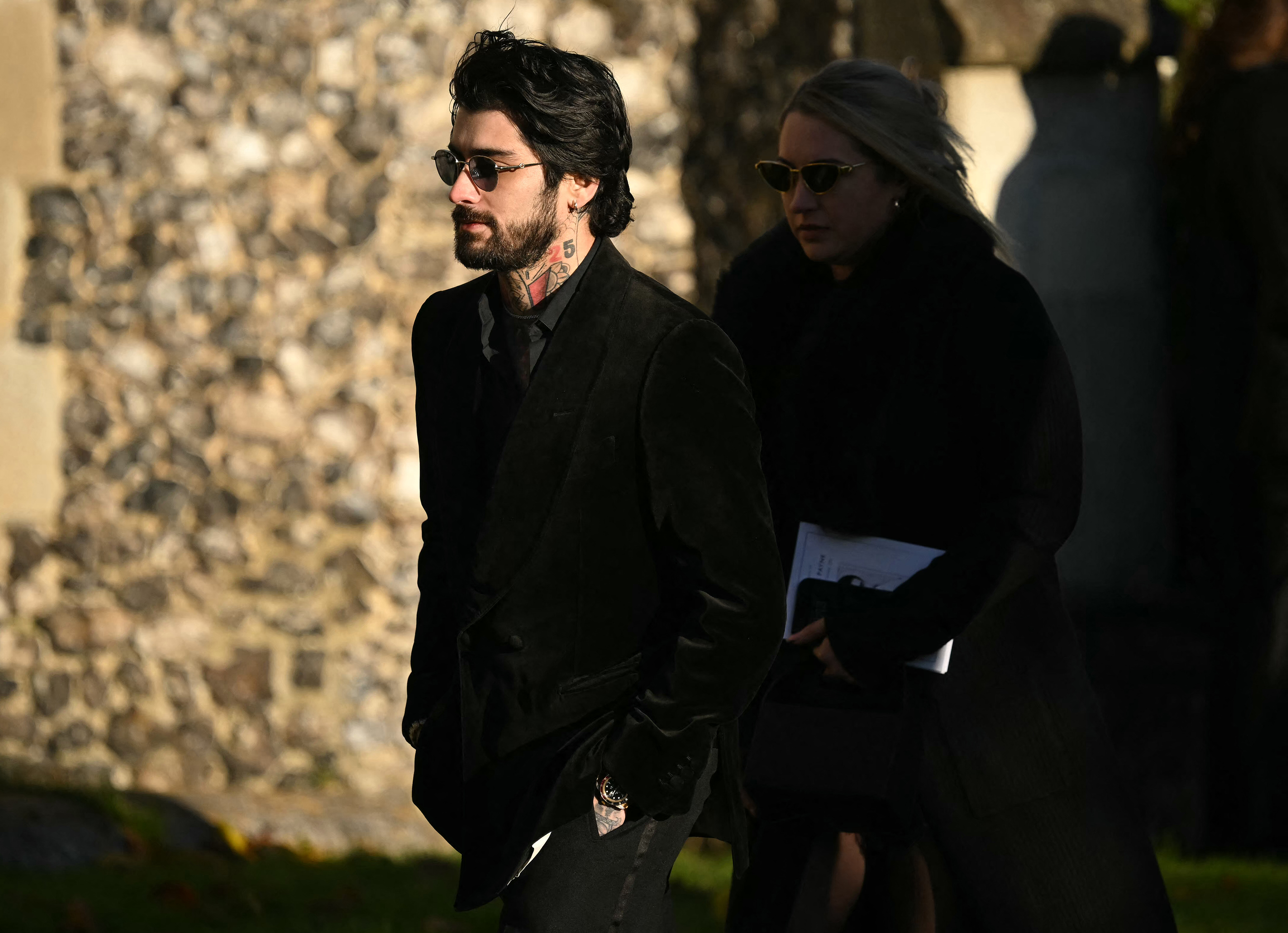El ex miembro de la banda One Direction, Zayn Malik (izq.), se va después de asistir al funeral del fallecido cantante de One Direction, Liam Payne.
