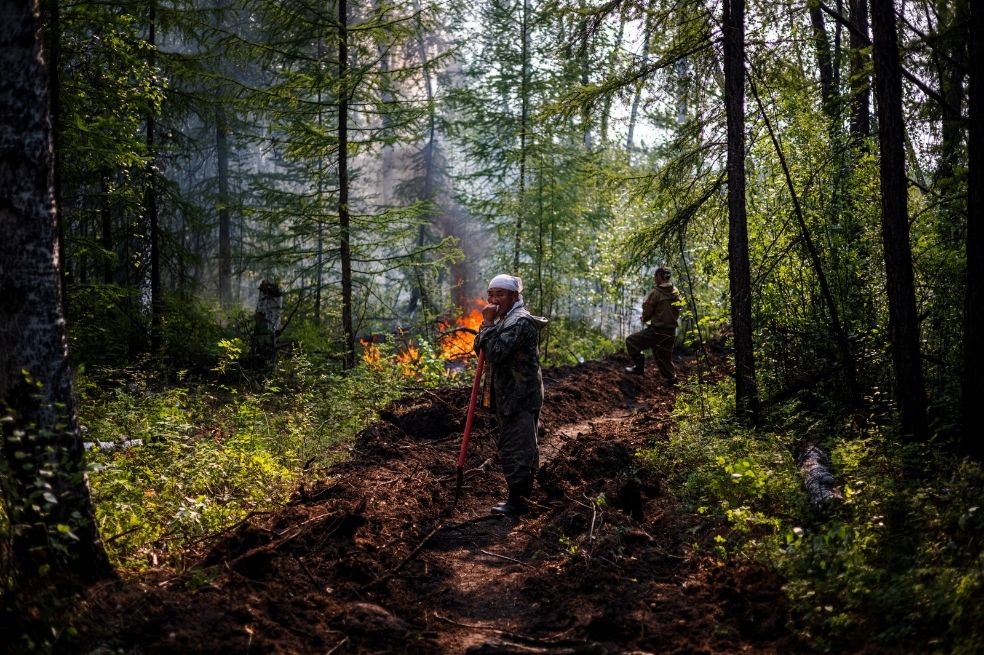 Un anciano ayuda a los bomberos a apagar un incendio en Yakutia, una de las zonas más frías de Siberia, donde también hay temporada de incendios.