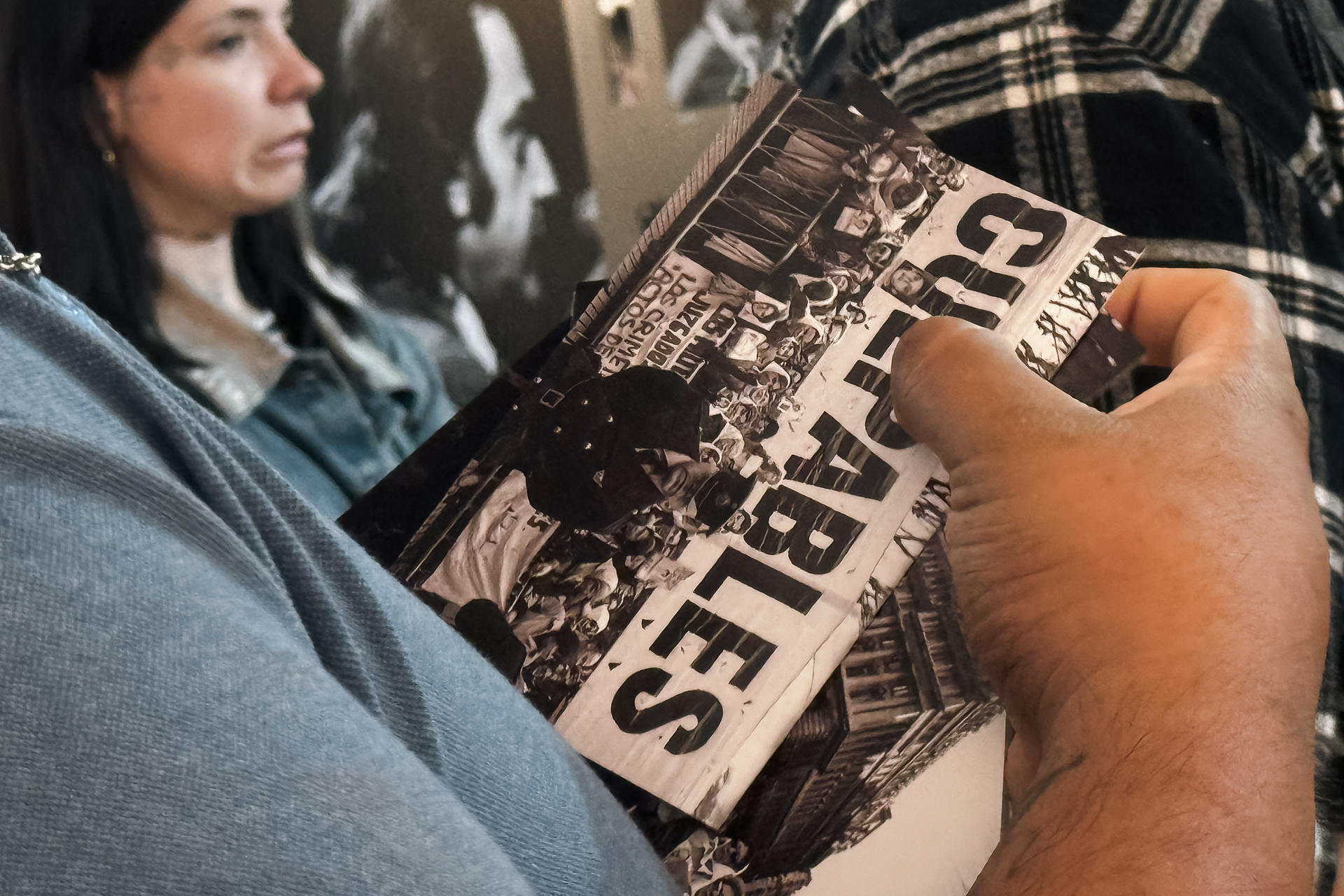 AME7042. BUENOS AIRES (ARGENTINA), 09/12/2025.- Una persona sostiene un libro durante la muestra fotográfica realizada con motivo del 40.º aniversario de la sentencia del Juicio a las Juntas este martes, en la Defensoría del Pueblo de la Ciudad de Buenos Aires (Argentina). Argentina conmemoró los 40 años de la condena a los líderes de la última dictadura cívico-militar (1976-1983), con un homenaje a los jueces de aquel proceso por parte de la Corte Suprema y un llamado de Estela de Carlotto, presidenta de Abuelas de Plaza de Mayo, "a continuar este camino tan necesario". EFE/ Juan Ignacio Roncoroni.