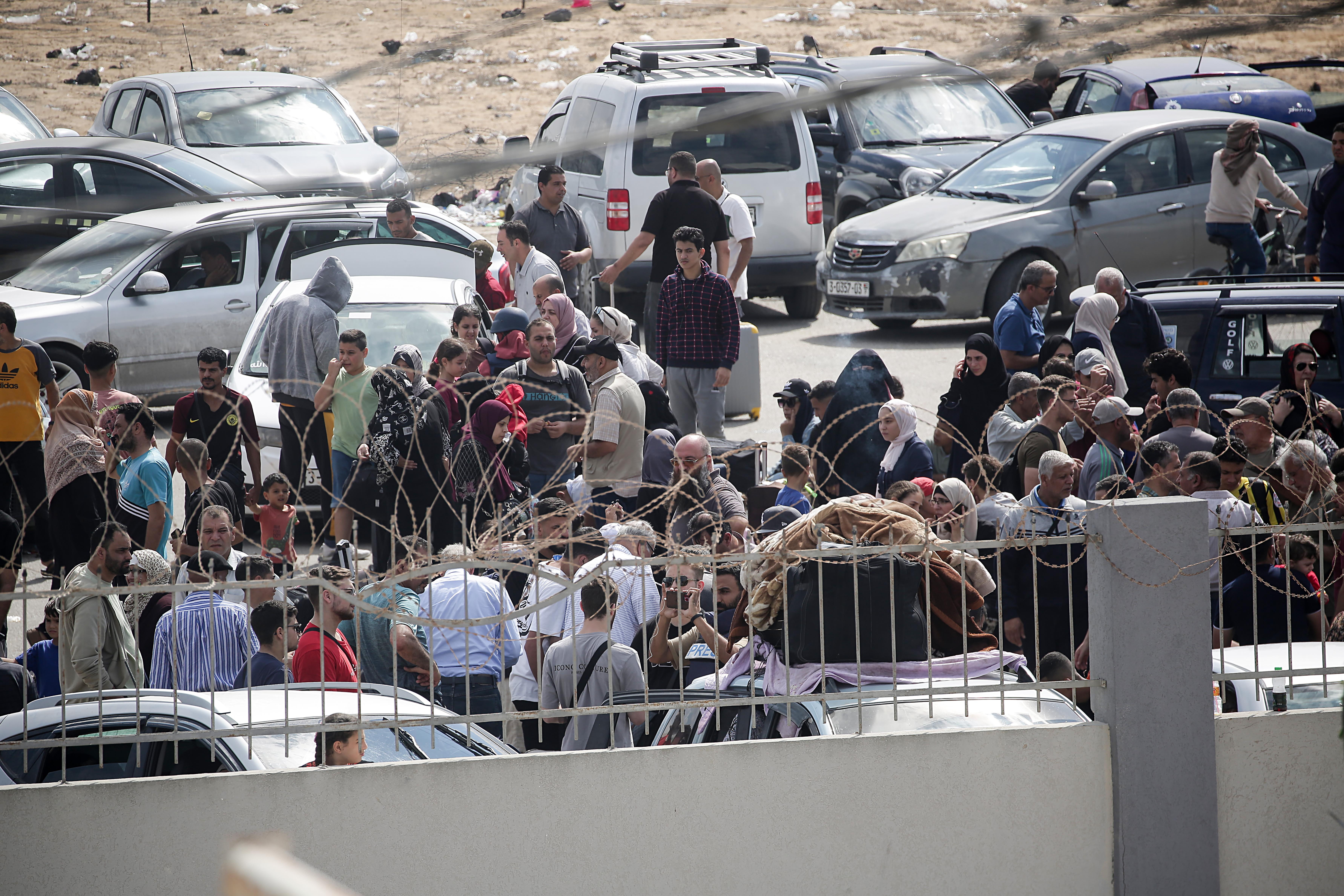 -FOTODELDÍA- GAZA, 16/10/2023.- Palestinos con doble nacionalidad esperan para cruzar a Egipto, este lunes en el sur de Gaza. Israel advirtió a los ciudadanos de Gaza de que debían desplazarse al sur de la franja antes del inicio de lo que se espera sea una invasión terrestre. Más de 2750 palestinos y 1300 israelíes han fallecido según datos oficiales de ambas partes desde el pasado 7 de octubre, momento en el que Hamas comenzó un ataque en territorio israelí. EFE/HAITHAM IMAD