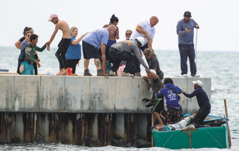 Los residentes ayudan a los inmigrantes cubanos a llegar a la costa cerca de Key West, Florida, el viernes 12 de agosto de 2022. El número de cubanos que abandonarán la isla alcanzará un máximo histórico este año. La Guardia Costera de Estados Unidos ha interceptado a muchos en el mar, pero muchos más están cruzando la frontera entre Estados Unidos y México. (Foto AP/Mary Martín)