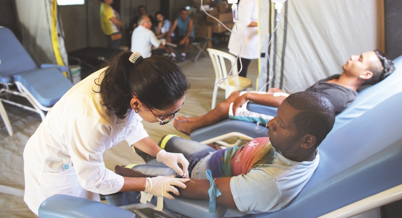 Personal sanitario toma una muestra de sangre a un paciente. / AP