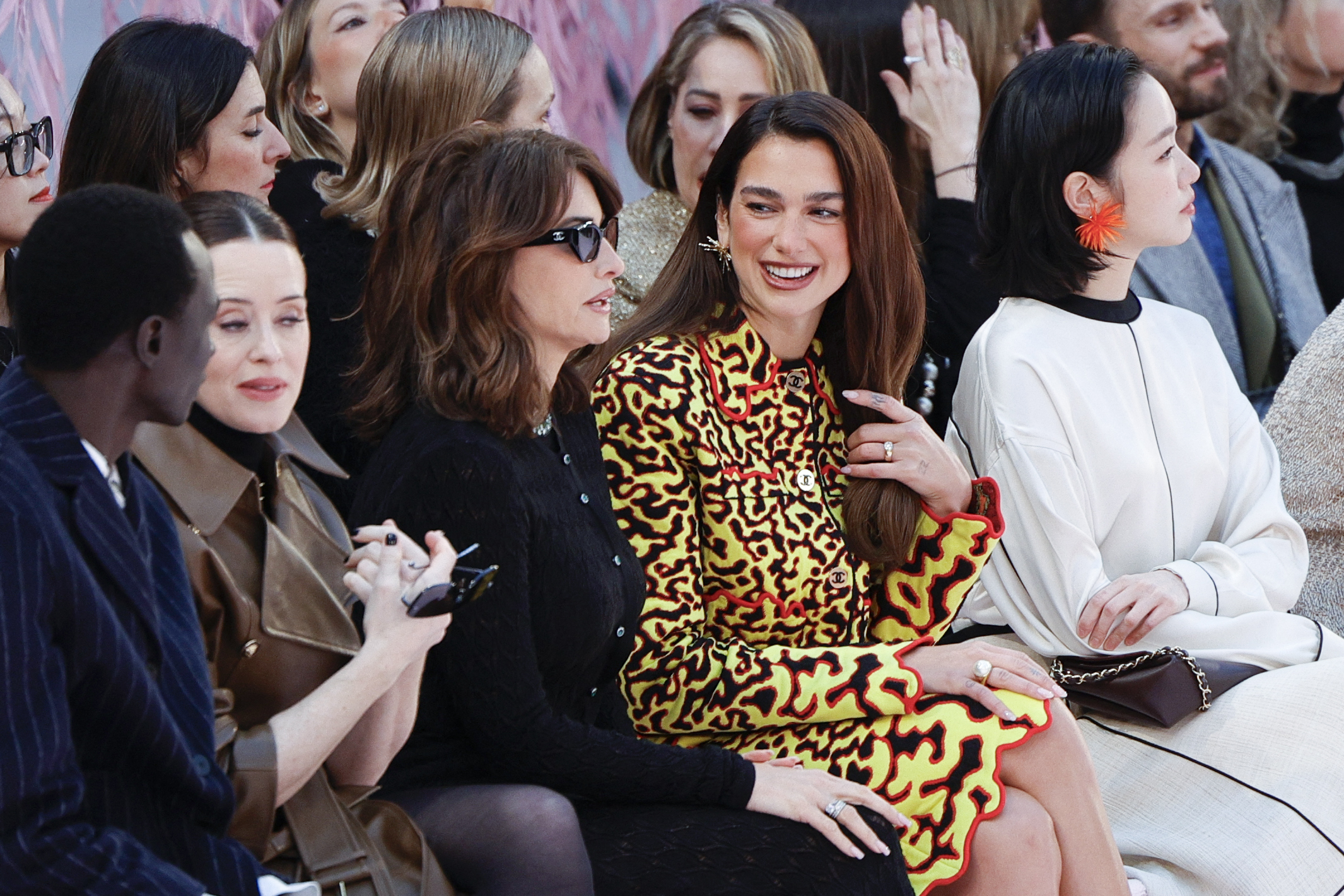 La actriz española Penélope Cruz (centro izquierda) conversa con la cantautora británica Dua Lipa (centro derecha) durante el desfile de la colección de alta costura primavera/verano 2026 de Chanel, en el marco de la Semana de la Alta Costura de París, el 27 de enero de 2026. / Geoffroy Van Der Hasselt / AFP