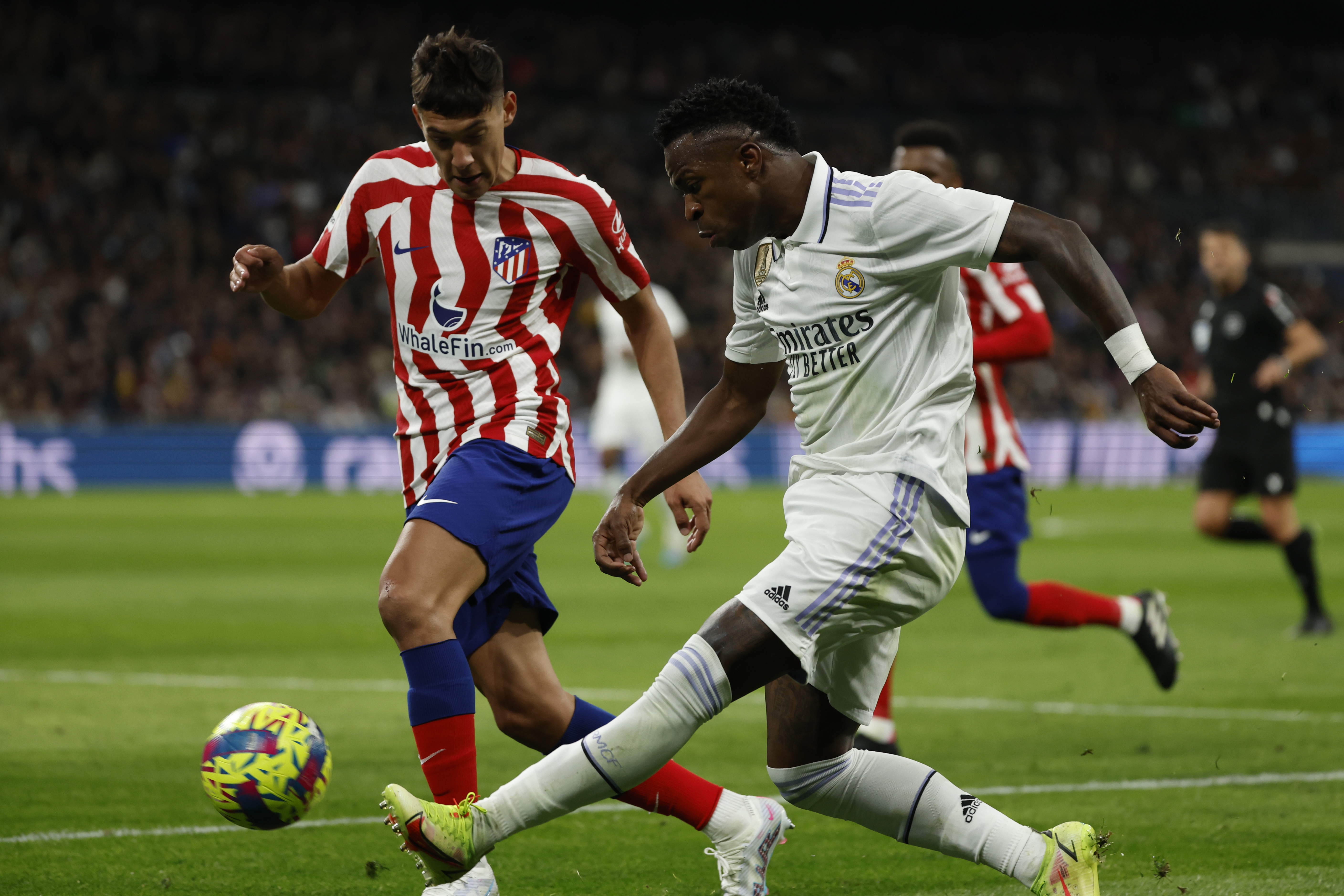 MADRID 25/02/2023.- El delantero brasileño del Real Madrid Vinicius Jr. (d) centra el balón durante el partido de la jornada 23 de LaLiga que enfrenta este sábado al Real Madrid y al Atlético de Madrid en el estadio Santiago Bernabéu, en Madrid. EFE/Juanjo Martín