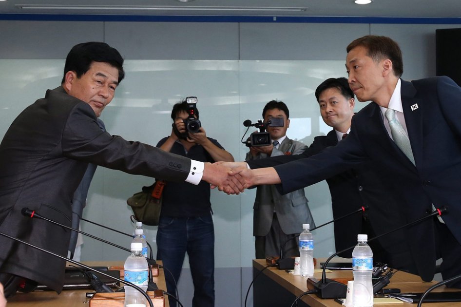 El director general del Distrito Inter Coreano, Kim Ki-Woong (d), saludando a su homologo de Corea del Norte Park Chul-Soo (i) antes de reunirse en el complejo industrial de Kaeseong./ EFE