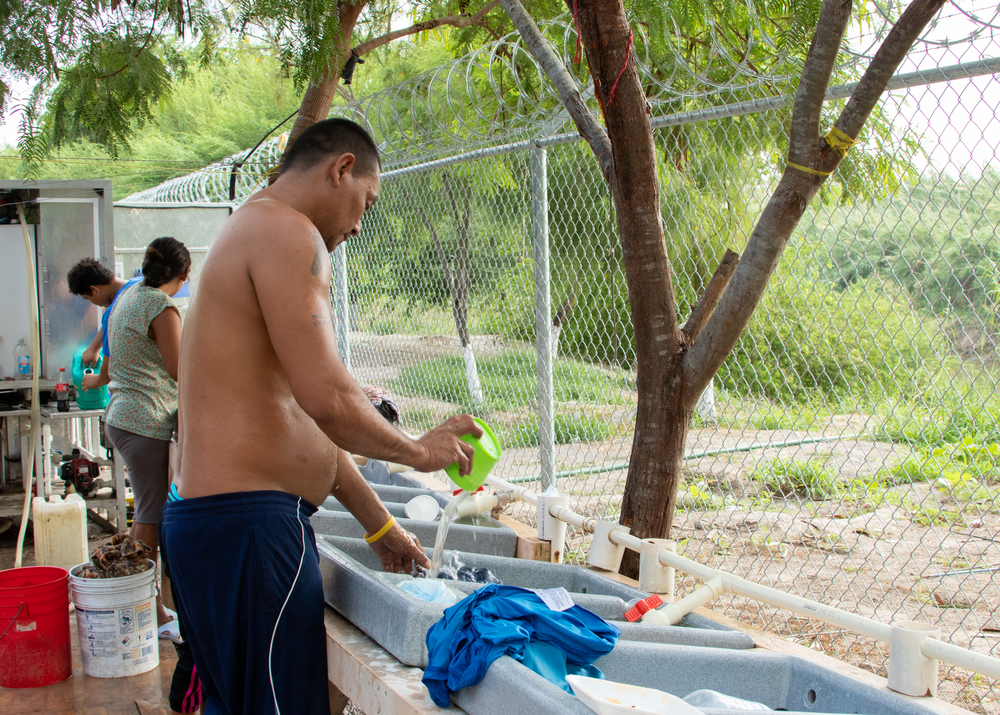 Solicitante de asilo lavando ropa en uno de los puntos de agua establecidos en el campamento. Estos lugares se abastecen hasta cuatro veces al día, en especial cuando la temperatura sube a más de 40 grados centígrados.