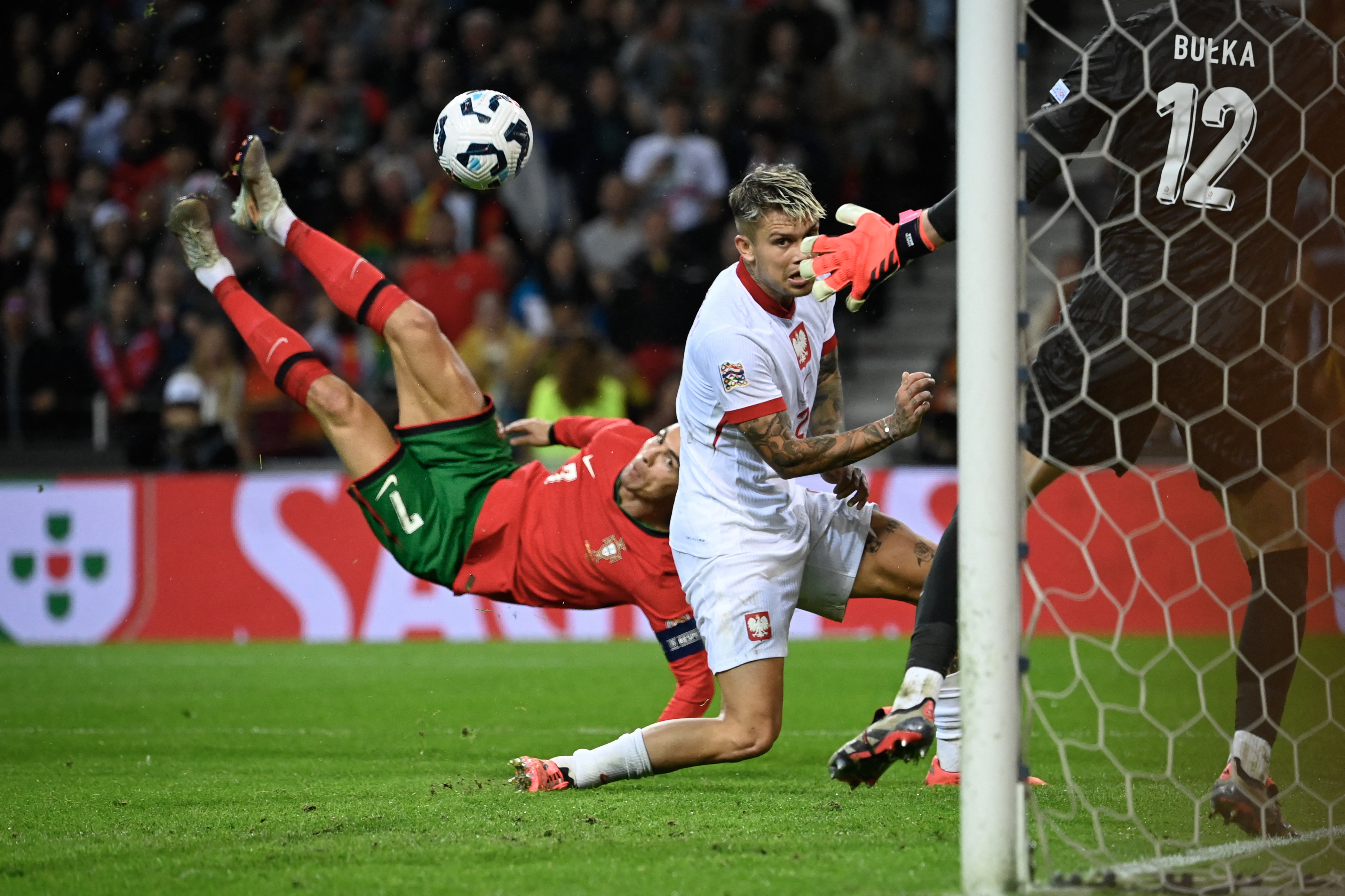 Portugal's forward Cristiano Ronaldo (L) scores their fifth goal during the UEFA Nations League, League A, Group 1 football match between Portugal and Poland at the Dragao stadium in Porto, on November 15, 2024. (Photo by Miguel RIOPA / AFP)