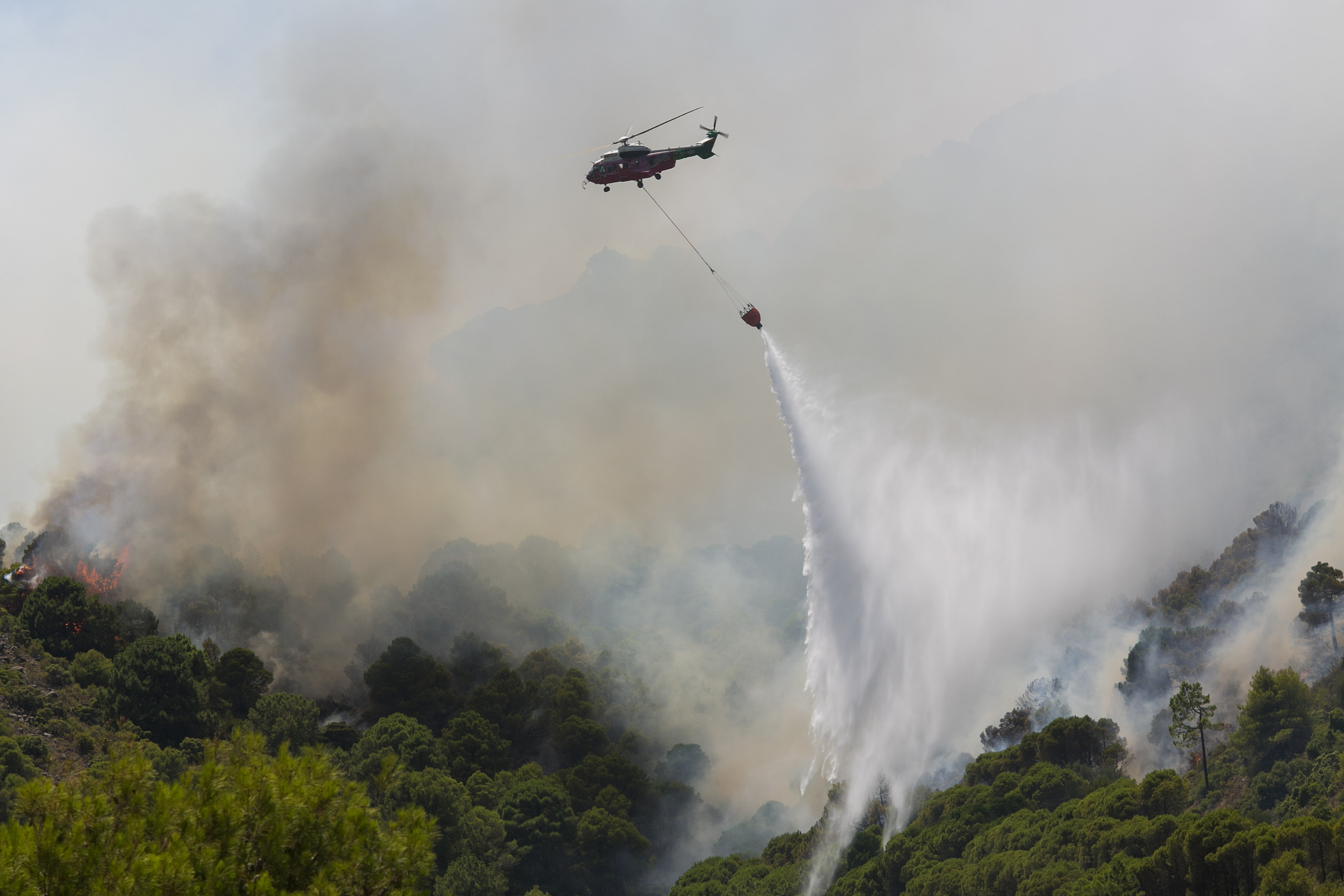 -FOTODELDÍA- ALHAURÍN DE LA TORRE (MÁLAGA) 16/07/2022.- Un helicóptero del servicio de bomberos trabaja en el incendio declarado en la sierra de Mijas, Málaga, este sábado. EFE/Álvaro Cabrera