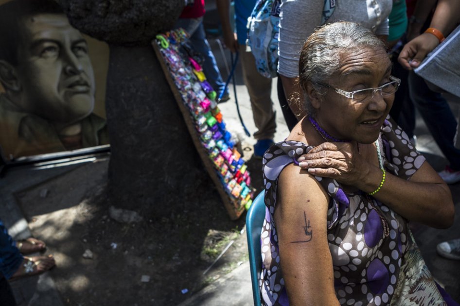 Una mujer se tatúa la firma del fallecido presidente Hugo Chavez durante una jornada oficial denominada 'Legado eterno del comandante Chávez'