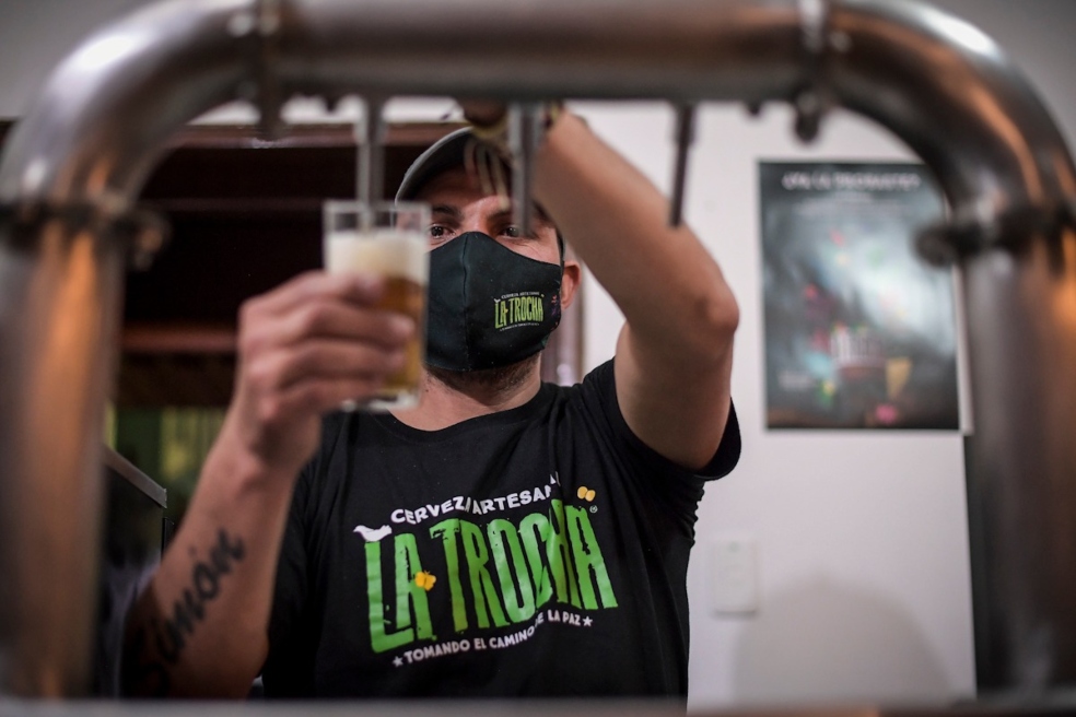 Un hombre, Sirve un vaso de Cerveza en la nueva casa de La Trocha, en Chapinero