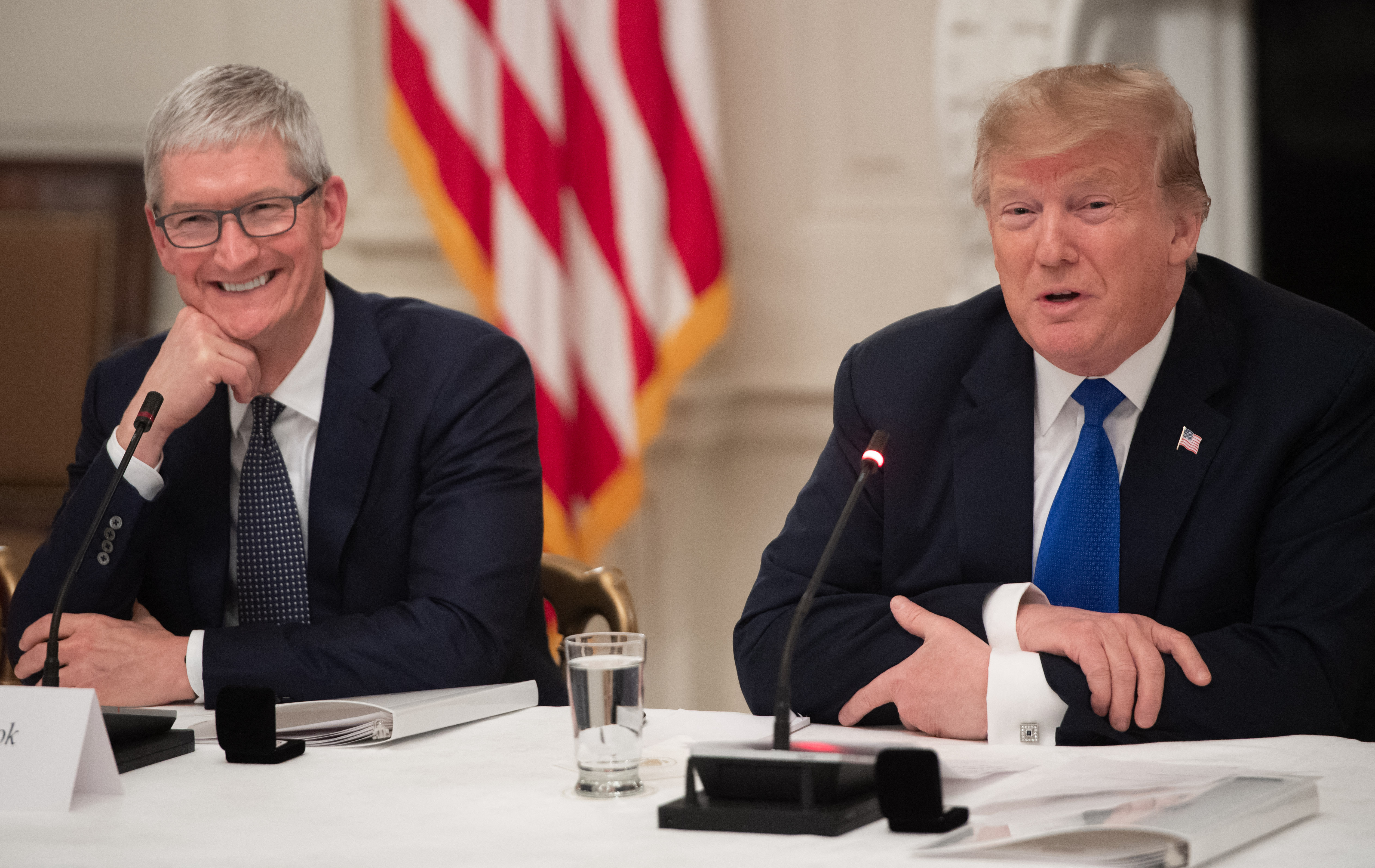 (FILES) US President Donald Trump speaks alongside Apple CEO Tim Cook (L) during the first meeting of the American Workforce Policy Advisory Board in the State Dining Room of the White House in Washington, DC, March 6, 2019.