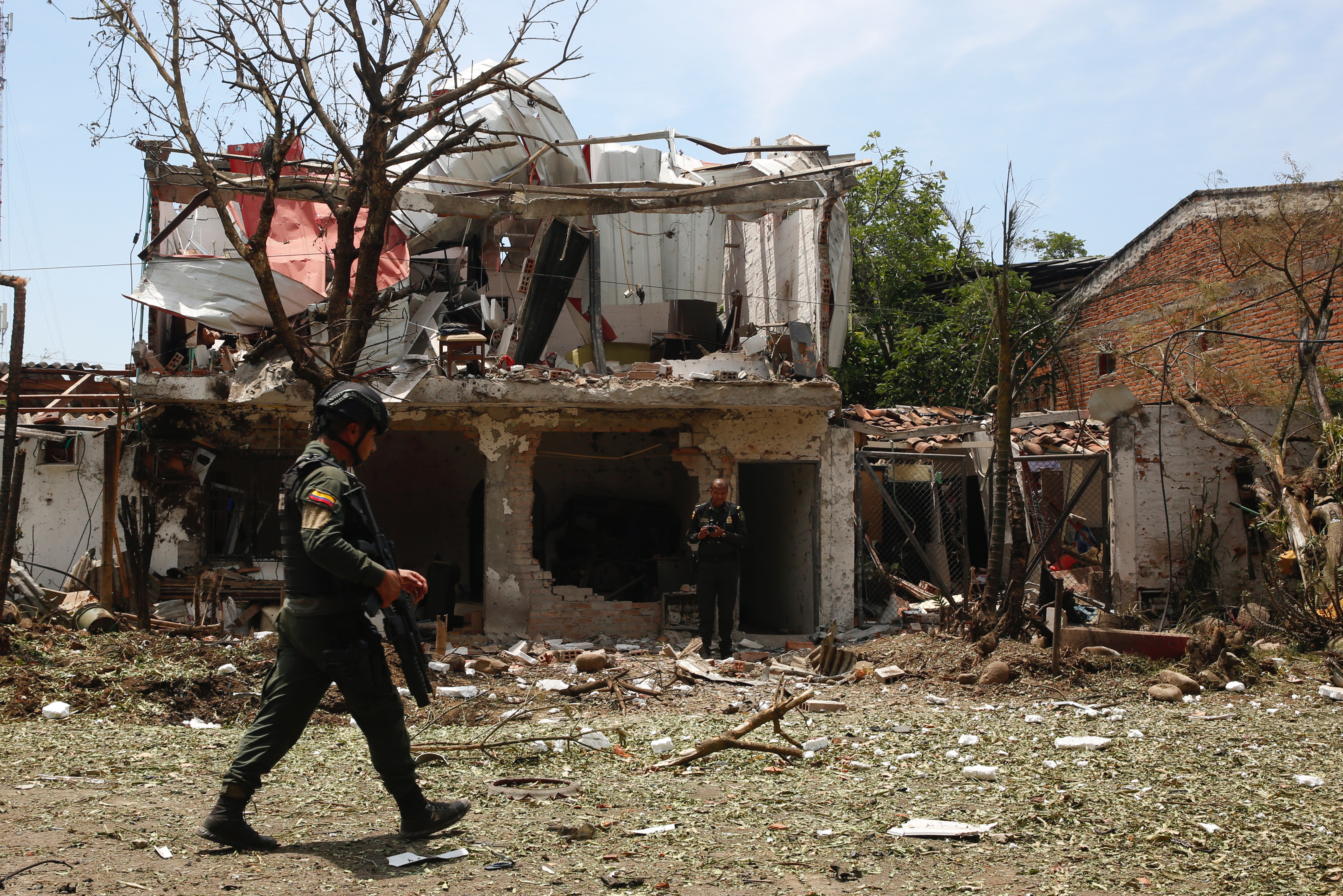 AME1786. JAMUNDI (COLOMBIA), 22/09/2023.- Un policía camina cerca de una vivienda destruida por un carro bomba, activado contra una subestación de policía hoy, en el corregimiento Potrerito, del municipio de Jamundí, Valle del Cauca (Colombia). Al menos cinco personas resultaron heridas este viernes en una zona rural del departamento del Valle del Cauca después de la explosión de un carro bomba en cercanías de una estación policial de la localidad de Jamundí, informó la Policía. EFE/Ernesto Guzmán