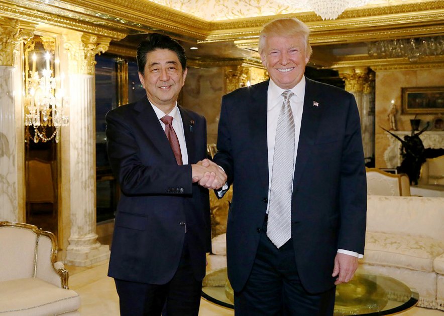 Shinzo Abe, primer ministro japonés, es el primer dirigente del mundo en estrechar la mano del presidente electo de Estados Unidos, Donald Trump. / AFP