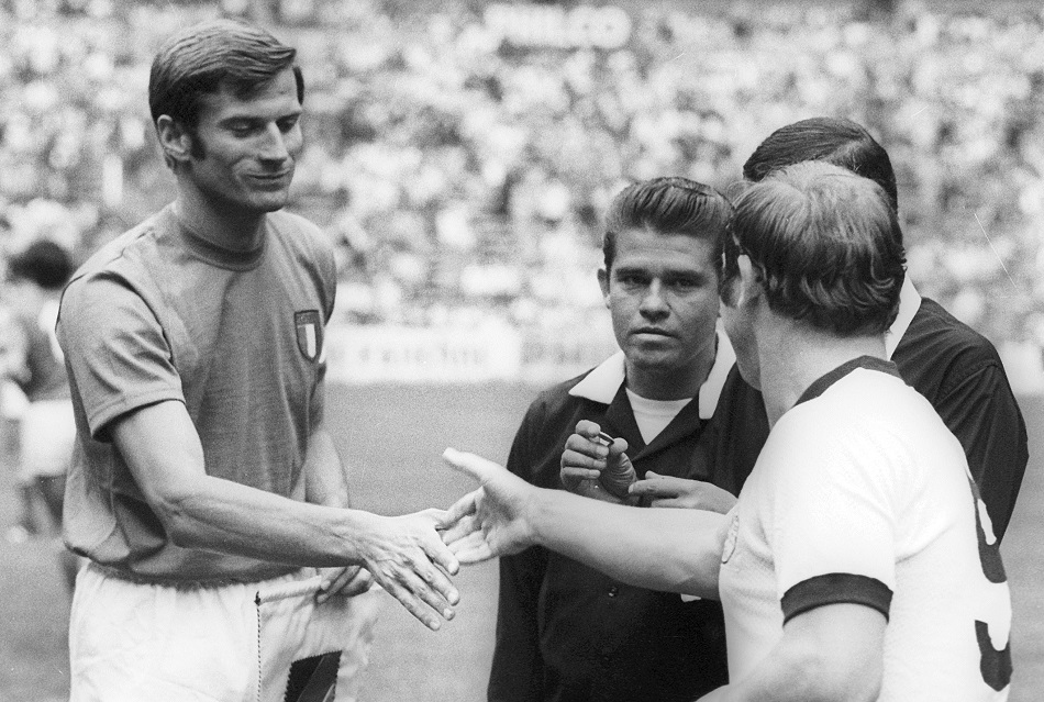 Giacinto Facchetti estrecha su mano con Uwe Seeler en la previa de la semifinal entre Alemania e Italia durante el mundial de México 1970 / DPA/AFP