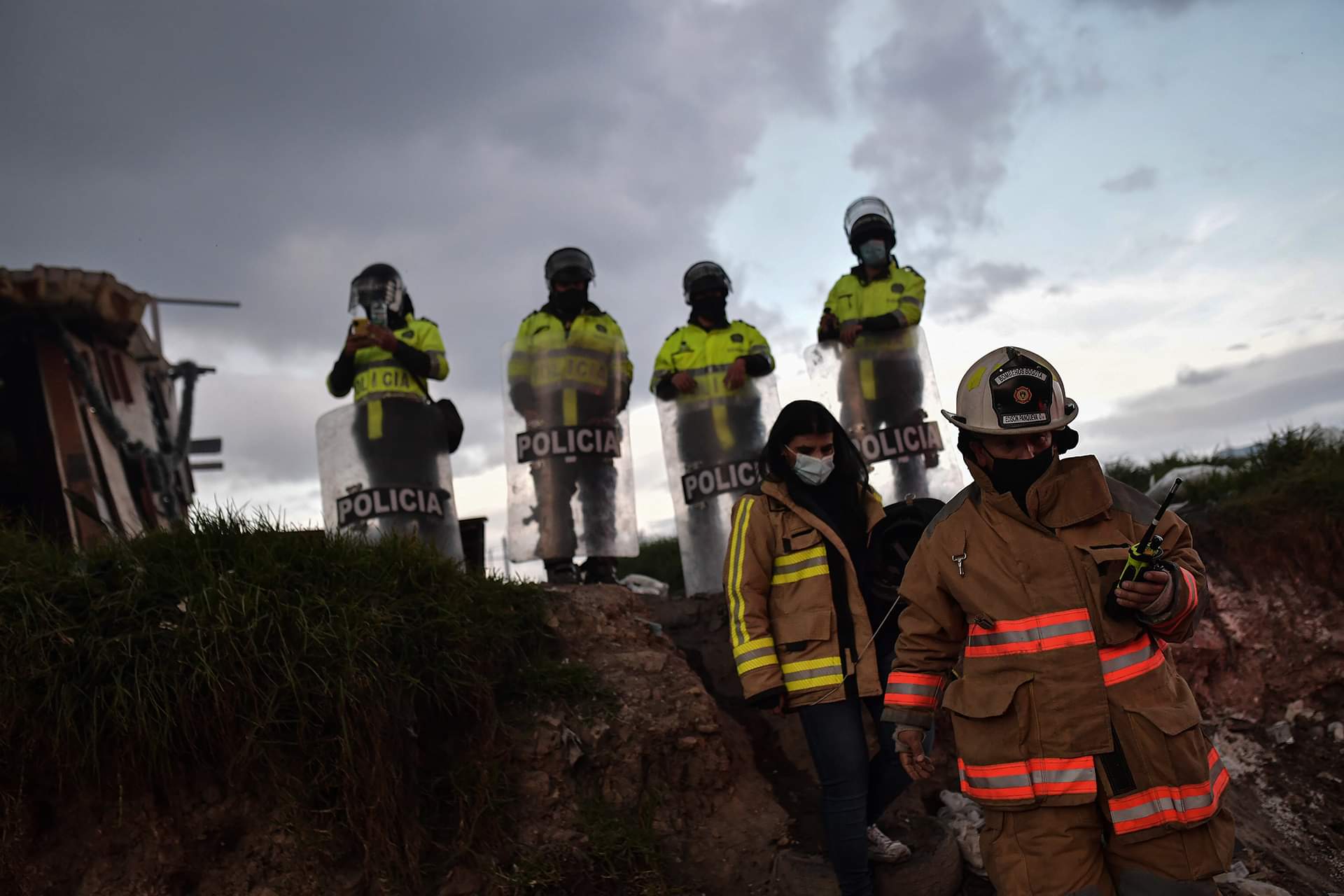 Cuatro policías y dos bomberos que van caminando de frente