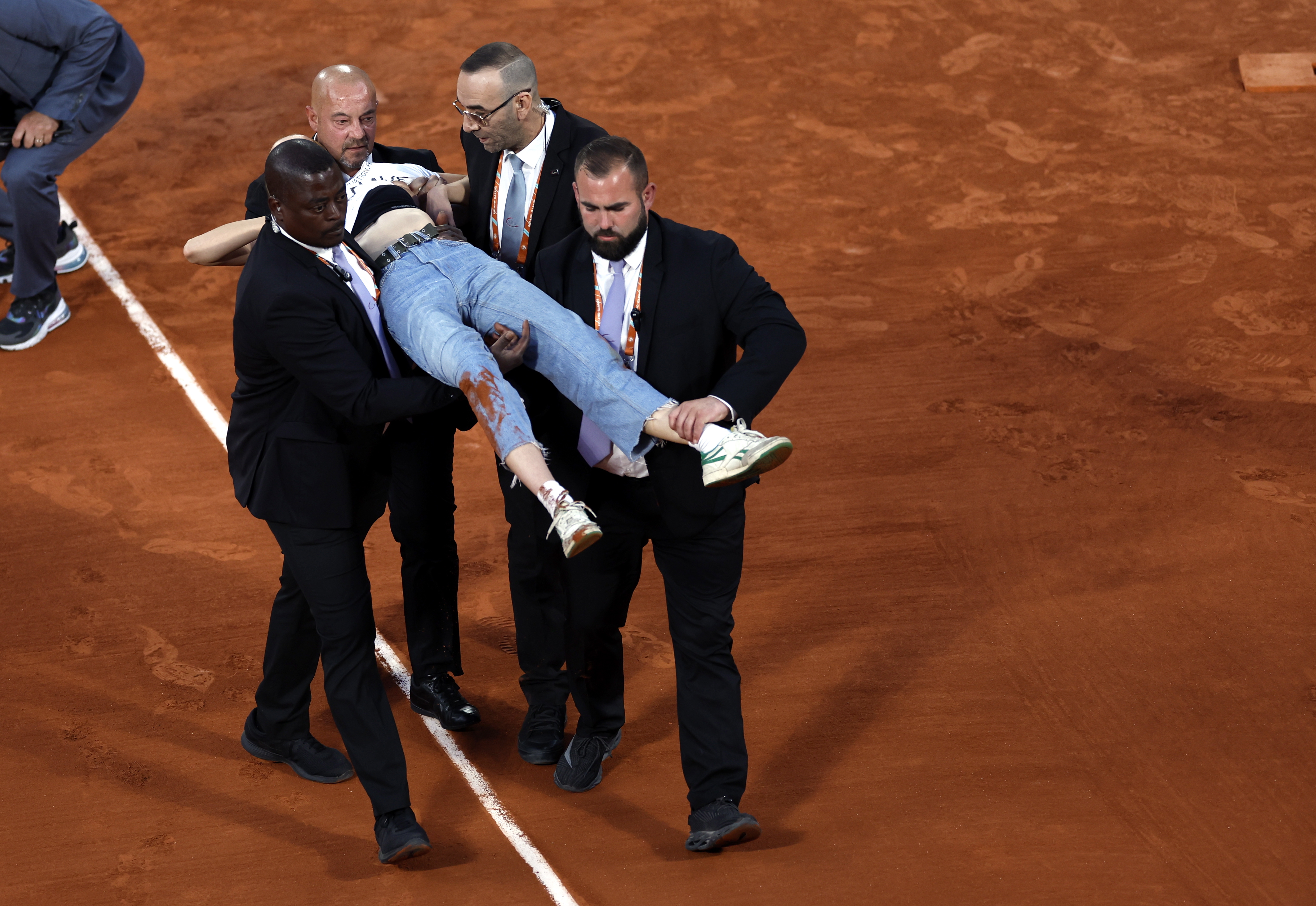 Paris (France), 03/06/2022.- An activist for climate protection is brought off the court after attaching herself to the net and thus caused an interruption of the men's semi final match Marin Cilic of Croatia vs Casper Ruud of Norway during the French Open tennis tournament at Roland Garros in Paris, France, 03 June 2022. (Tenis, Abierto, Abierto, Croacia, Francia, Noruega) EFE/EPA/YOAN VALAT