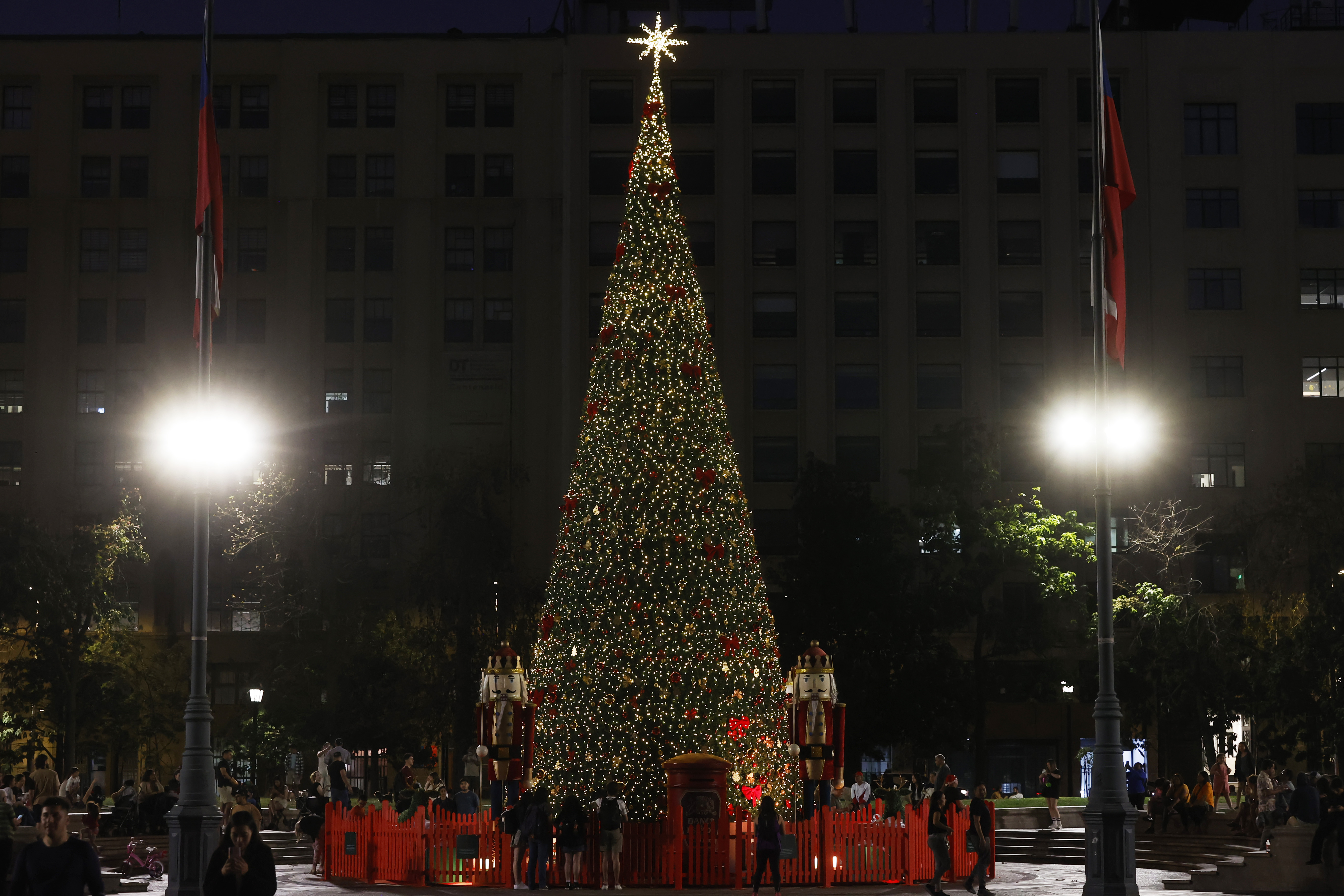 AME4676. SANTIAGO (CHILE), 10/12/2024.- Personas visitan un árbol de Navidad en la Plaza de la Constitución, este martes frente al palacio de La Moneda, en Santiago (Chile). EFE/ Elvis González