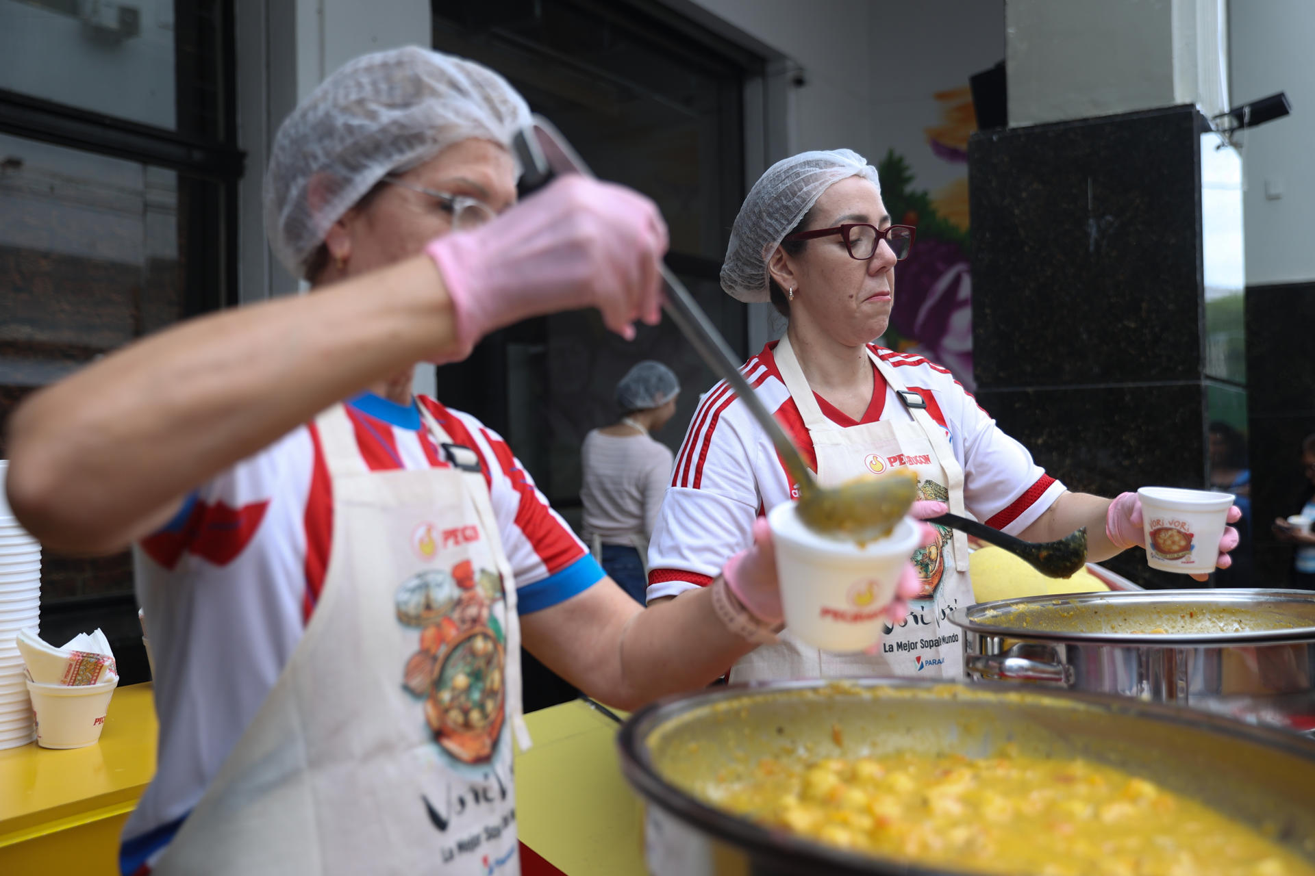 AME3300. ASUNCIÓN (PARAGUAY),14/04/2026.- Cocineras sirven el tradicional vorí vorí, un caldo de pollo y maíz, durante la celebración de su día nacional este martes, en Asunción (Paraguay). Cientos de entusiastas del vori vori, un caldo espeso representativo de la cocina de Paraguay, se reunieron para degustar del plato, al que orgullosamente denominaron como la "mejor sopa del mundo" después de que la enciclopedia gastronómica 'Taste Atlas' la reconociera como tal por dos años consecutivos. EFE/ Juan Pablo Pino
