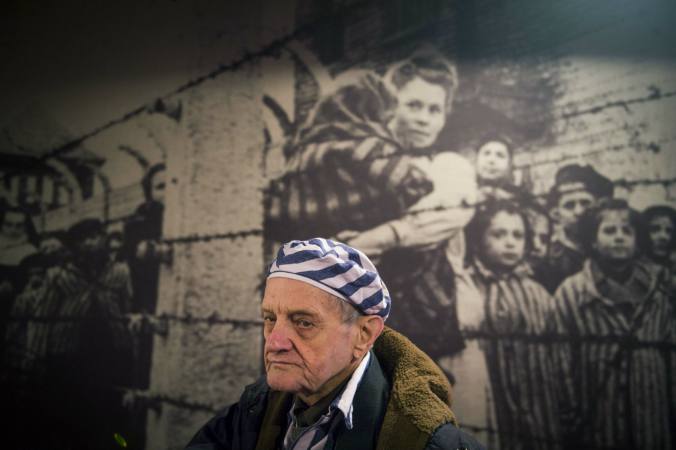  Igor Malitski, sobreviviente ucraniano del Holocausto pasa junto a unapintura en una de las barracs del campo de concentración de Auschwitz en Oswiecim. Sobrevivientes llegaron a la recordación del 70 aniversario de la liberación de este campo. / AFP