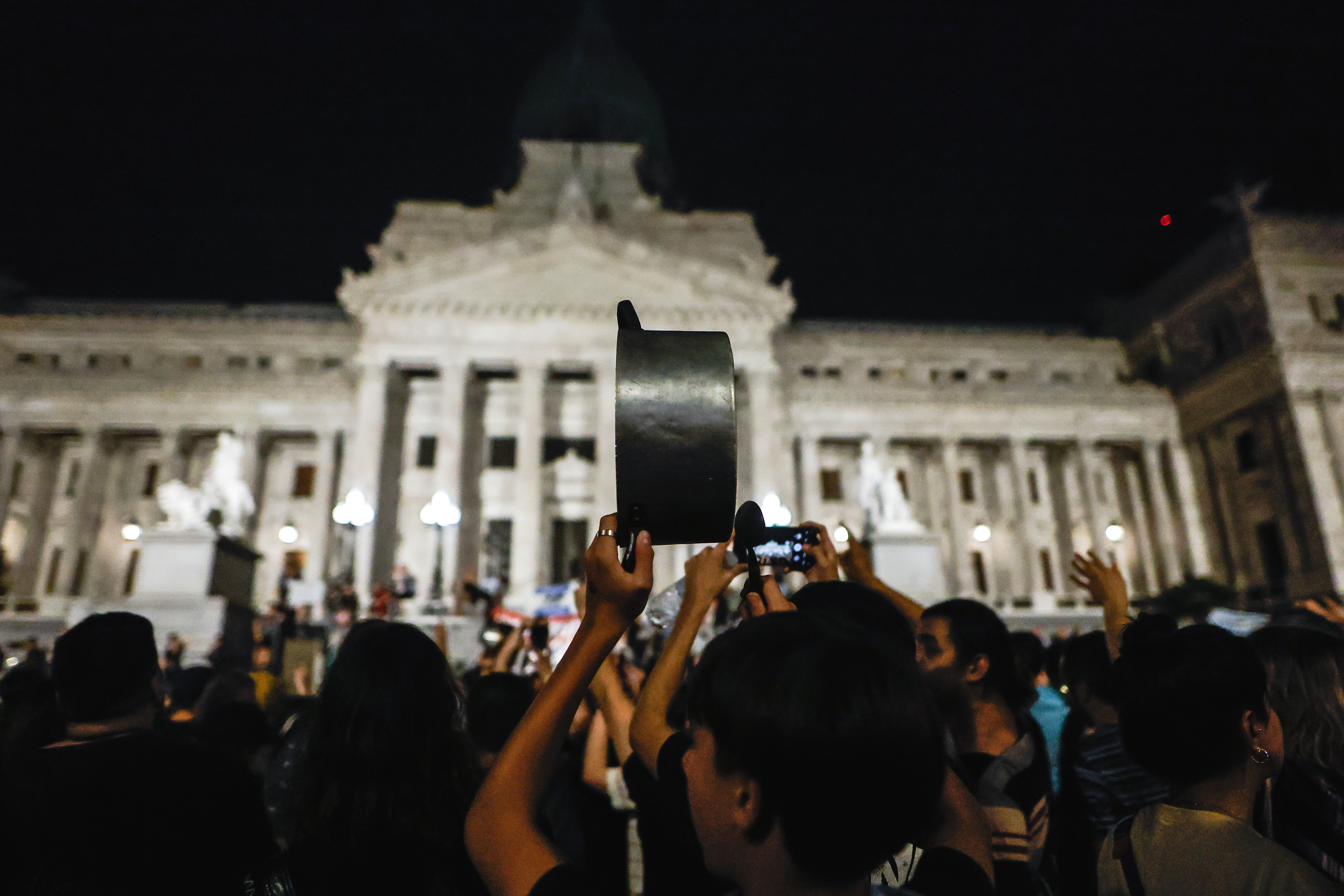 AME5547. CIUDAD DE BUENOS AIRES (ARGENTINA), 20/12/2023.- Un joven golpea una olla durante una manifestación contra las medidas anunciadas hoy por el presidente Javier Milei, frente al Congreso de la Nación en Buenos Aires (Argentina). Milei anunció la noche de este miércoles un plan que contempla la reforma de más de 300 normas para sentar "las bases de la reconstrucción de la economía argentina". El anuncio del plan de choque del Gobierno se produce el mismo día en que unas 3.000 personas convocadas por organizaciones sociales y de izquierda salieron a las calles de la capital argentina para mostrar su rechazo a la política del presidente ultraliberal. EFE/ Juan Ignacio Roncoroni