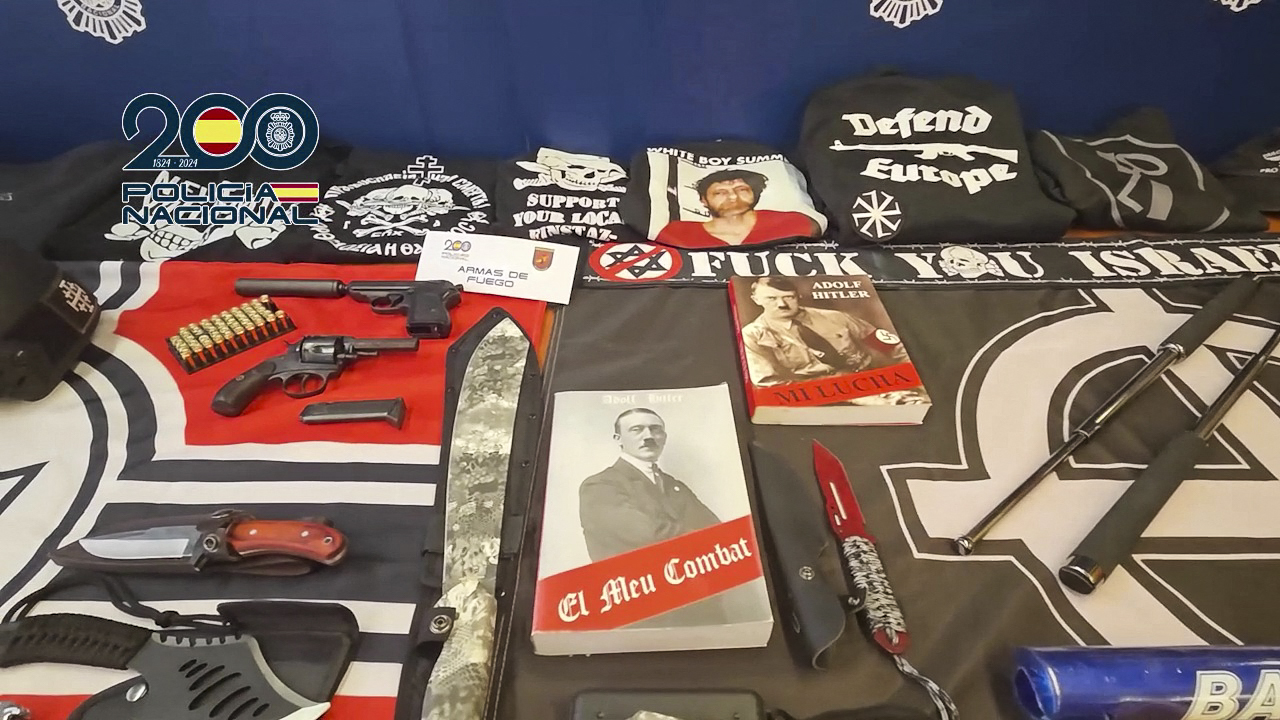 In this still image from video released on December 1, 2025 by the Spanish National Police material confiscated during operations against a Spanish branch of The Base, a neo-nazi supremacist organization, is displayed. Spanish police arrested three suspects including the suspected leader of The Base in Spain. (Photo by Handout / Spanish National Police / AFP) / RESTRICTED TO EDITORIAL USE - MANDATORY CREDIT "AFP PHOTO / POLICIA NACIONAL" - HANDOUT - NO MARKETING NO ADVERTISING CAMPAIGNS - DISTRIBUTED AS A SERVICE TO CLIENTS