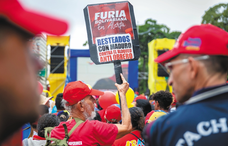 Un hombre sostiene una pancarta que dice "resteados con Maduro contra el bloqueo anti obrero", durante una marcha oficialista, en Caracas (Venezuela). 