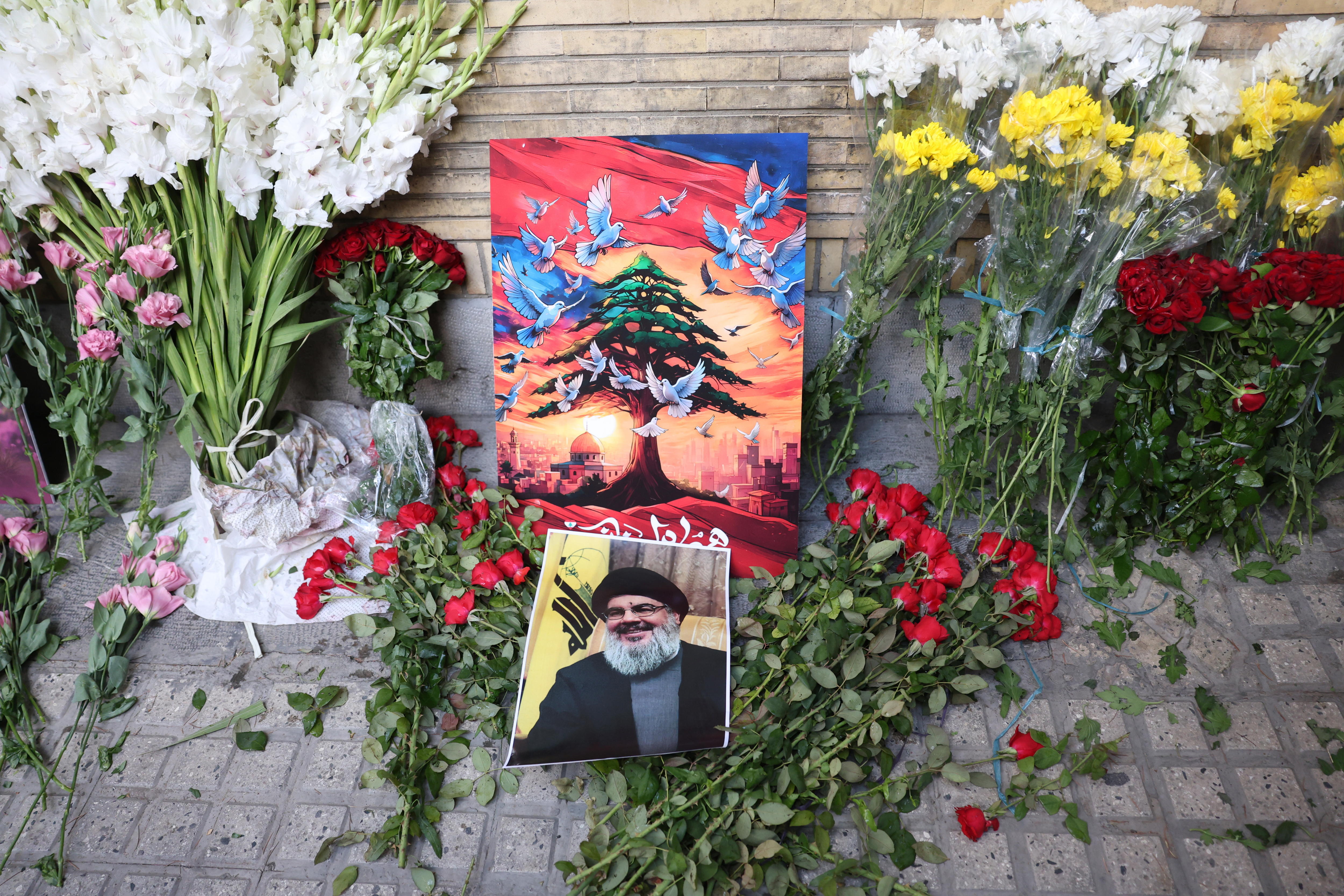 Tehran (Iran (islamic Republic Of)), 18/09/2024.- A picture of Hezbollah leader Hassan Nasrallah is placed next to flowers in front of the Lebanese embassy in Tehran, Iran, 18 September 2024. Lebanon's Ministry of Health said at least 12 people have been killed and more than 2,800 others injured after multiple wireless communication devices (pagers) were detonated on 17 September. Lebanon's Hezbollah declared in a statement that Israel was behind the attack. Iran's Ambassador to Lebanon Mojtaba Amani was among the wounded, Iran's Fars agency reported. (Líbano, Teherán, Hizbulá/Hezbolá) EFE/EPA/ABEDIN TAHERKENAREH