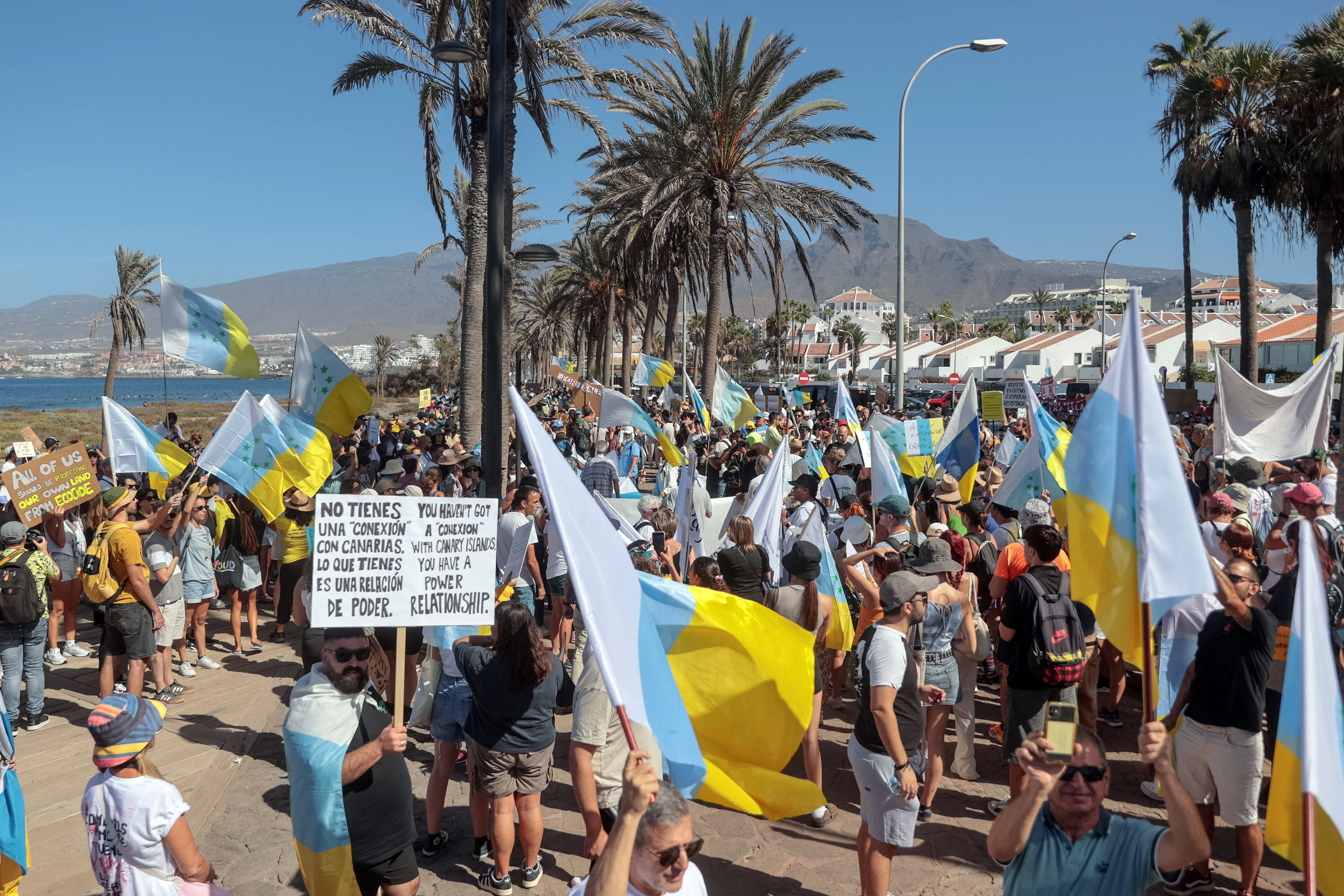 Protesters march along a street of Playa de las Americas during a demonstration to protest against mass tourism, in Arona on the Spanish Canary island of Tenerife, on October 20, 2024.