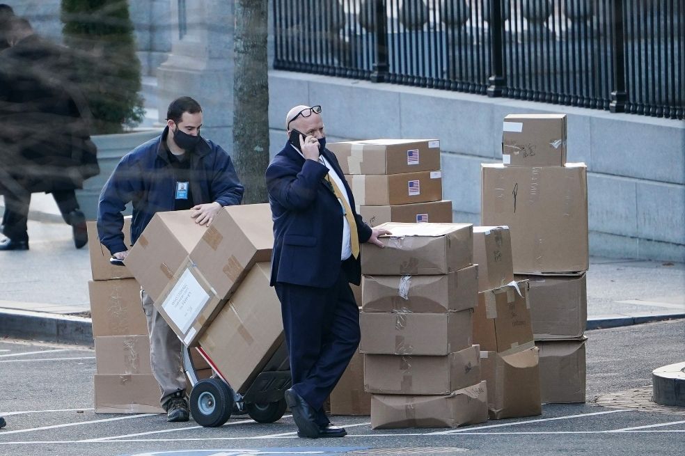 Un trabajador apila cajas en la West Executive Avenue antes de cargarlas en un camión en la Casa Blanca en Washington, D.C.