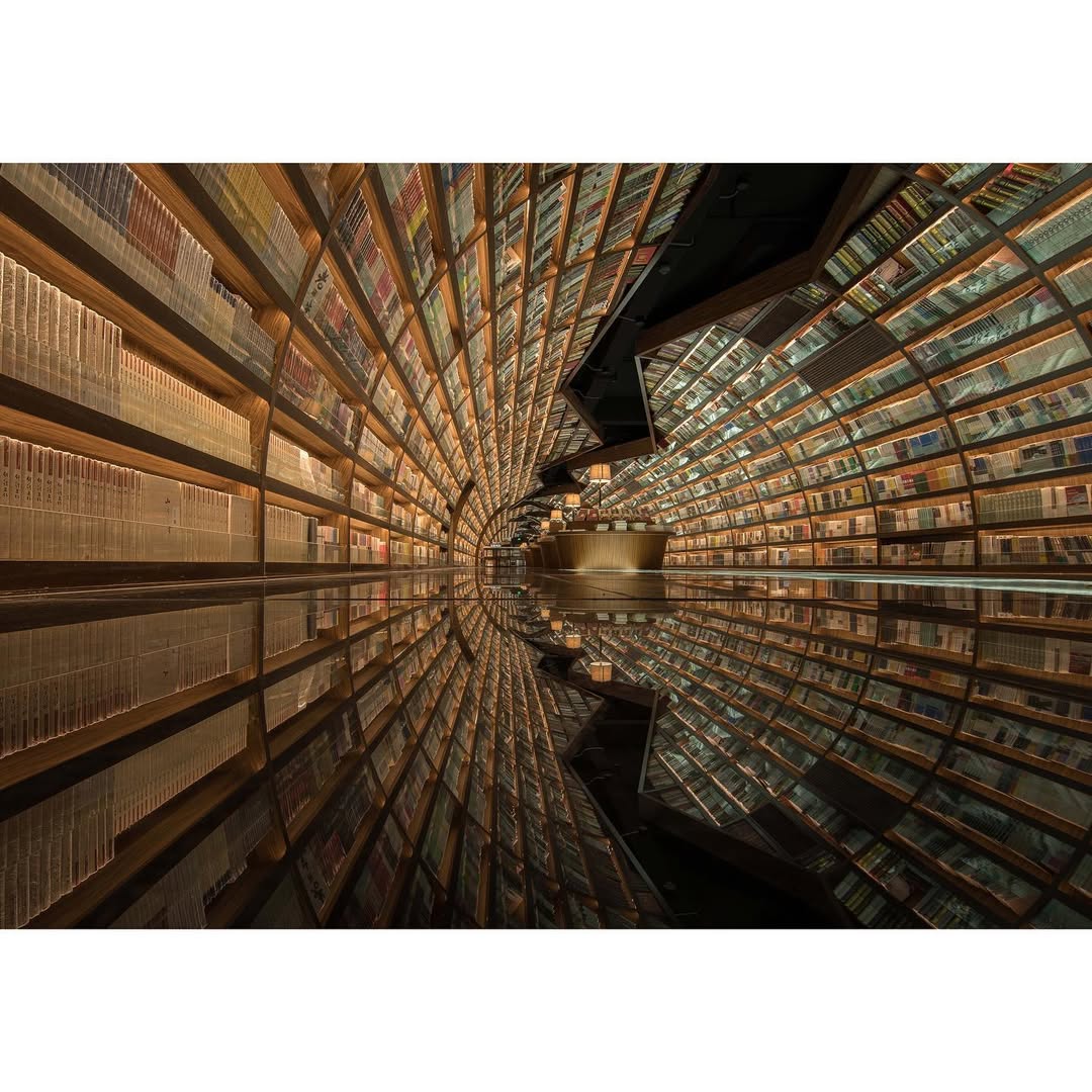 La librería Yangzhou Zhongshuge,  en China, diseñada por el estudio XL-Muse, lleva la experiencia de lectura a un nivel casi surrealista. Inspirada en los ríos y puentes de la ciudad, el espacio combina espejos, túneles de libros y estructuras que parecen no tener fin, creando la sensación de estar dentro de una historia. Cada zona propone un ambiente distinto, desde rincones íntimos para leer hasta áreas que evocan paisajes imaginarios, pero es el espacio infantil —con elementos lúdicos y transformables— el que termina de convertirla en un lugar tan excesivo como fascinante.