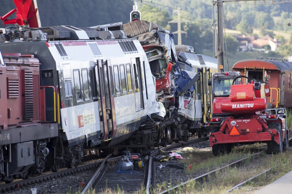 Miembros de los servicios de emergencia trabajan en las labores de retirada de uno de los vagones tras la colisión de dos trenes en Granges-près-Marnand, oeste de Suiza./ EFE
