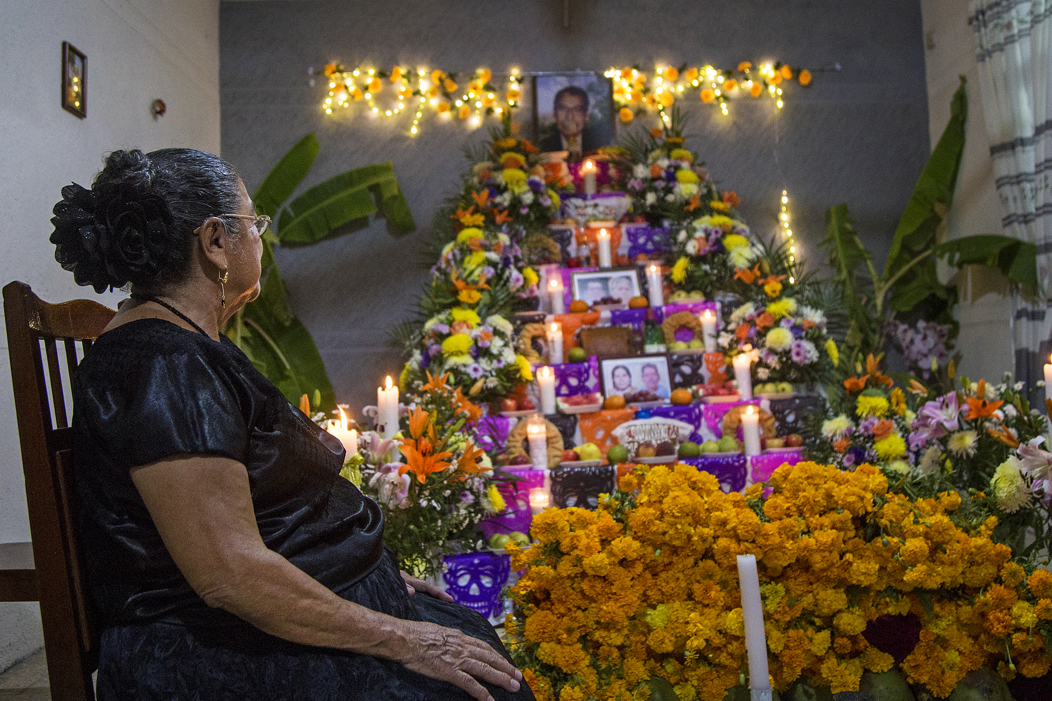 MEX4094. JUCHITÁN (MÉXICO), 31/10/2024.- Una mujer zapoteca posa junto a una ofrenda de Día de Muertos este jueves, en el municipio de Juchitán (México). Con la celebración del 'Xandú' equivalente a todos los santos, pobladores montan ofrendas y altares con comida, panes y algunas bebidas de la predilección del difunto para recibirlos y convivir con ellos. EFE/ Luis Villalobos