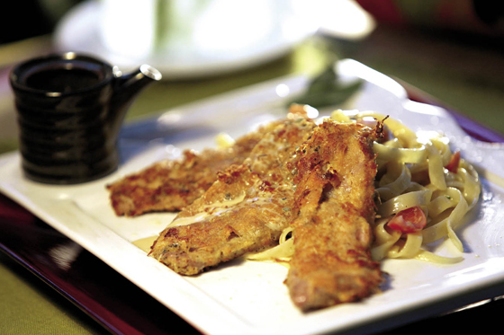 Escalopes de ternera apanada con queso parmesano sobre tallarines