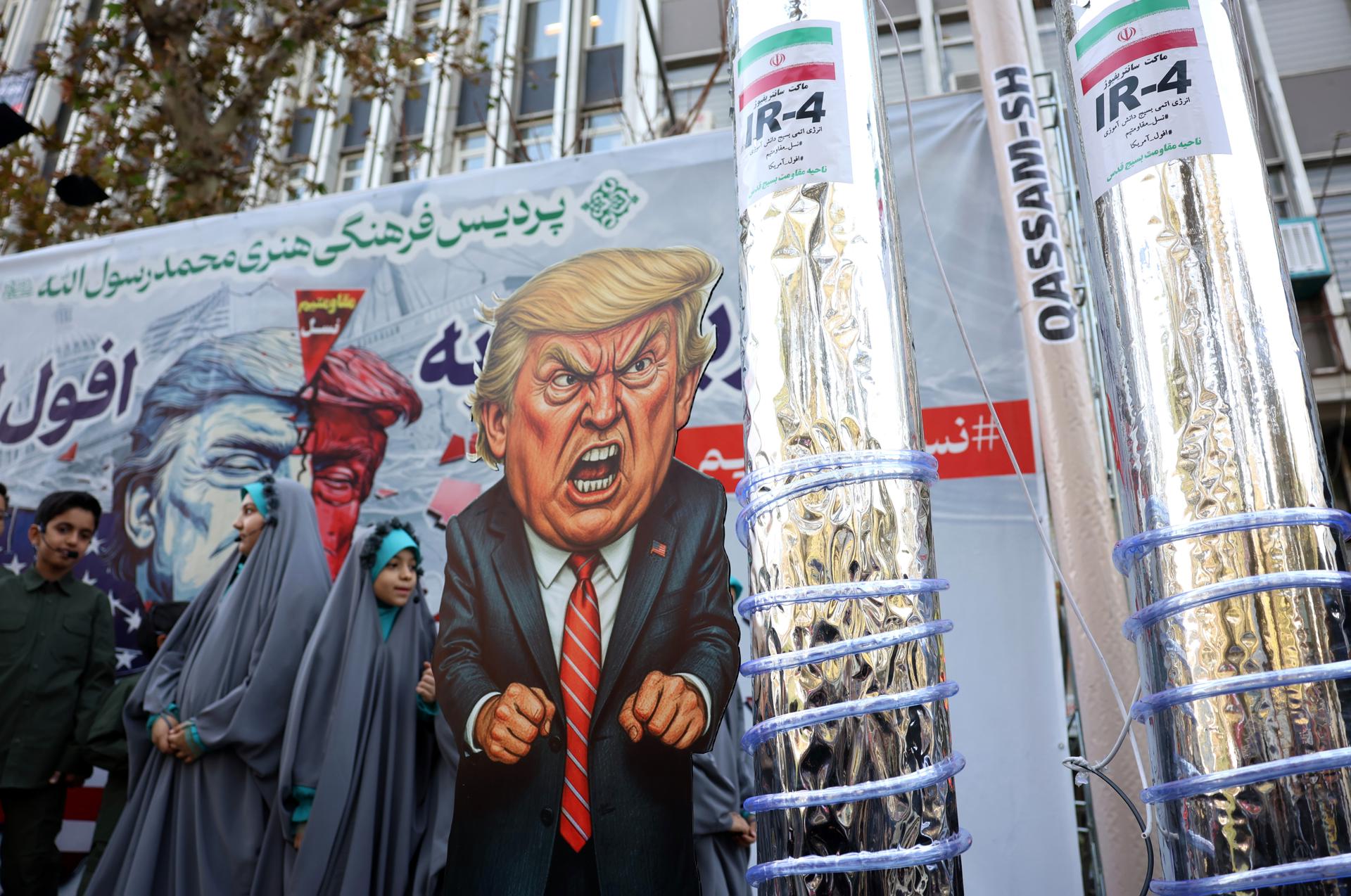 TEHRAN (IRAN(Islamic Republic Of)), 04/11/2025.- Iranians pass by a cartoon of US President Donald Trump next to symbols of Iranian nuclear centrifuges as they participate in an anti-US rally to mark the 46th anniversary of the US Embassy takeover, in Tehran, Iran, 04 November 2025. The rally commemorates the 1979 US Embassy hostage crisis, which began when Iranian students occupied the embassy after the US allowed the late Shah to be hospitalized in the United States. The crisis lasted 444 days, ending on 20 January 1981. (Estados Unidos, Teherán) EFE/EPA/ABEDIN TAHERKENAREH
