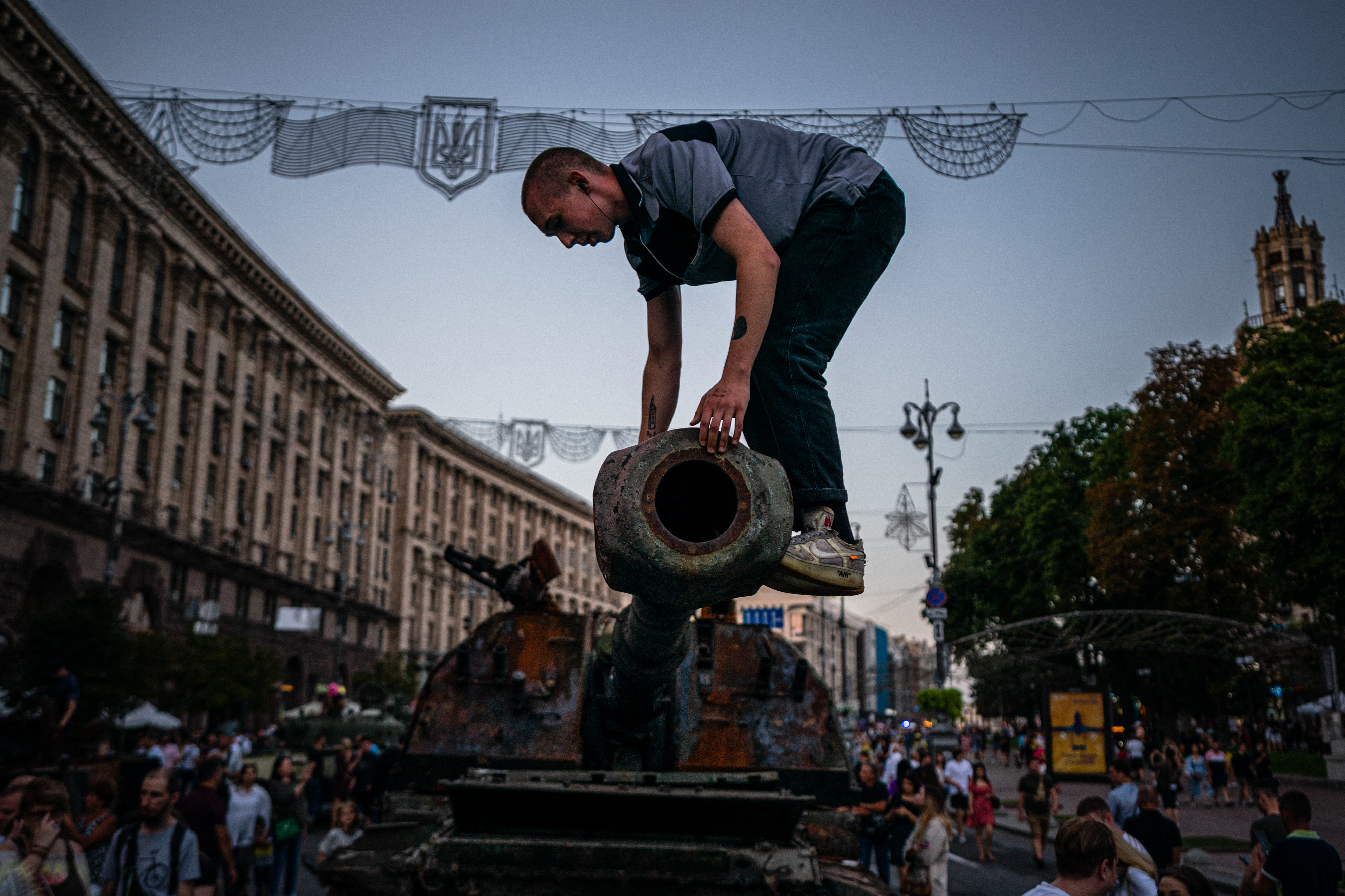 Un hombre se sube a un tanque ruso destruido en la calle Khreshchatyk en Kiev, que se ha convertido en un museo militar al aire libre antes del Día de la Independencia de Ucrania el 24 de agosto, en medio de la invasión rusa de Ucrania.