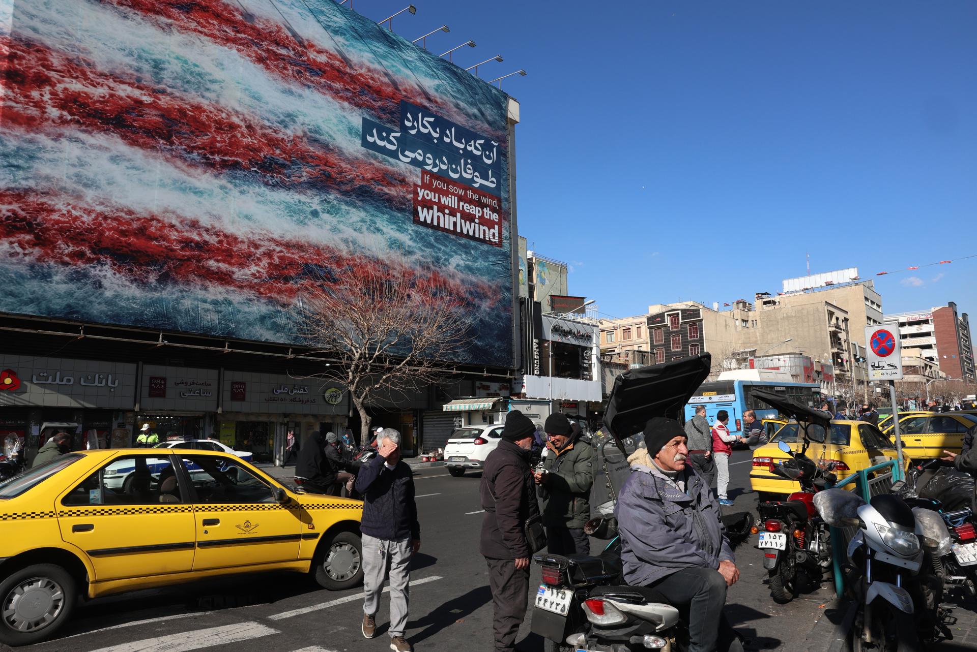 TEHRAN (Iran (Islamic Republic Of)), 31/01/2026.- Iranians walk near a huge anti-US billboard hanging at the Enqelab square in Tehran, Iran, 31 January 2026. The US President Donald Trump renewed threats of military action against Iran following anti-government protests. Iran is experiencing a nationwide internet blackout that began on 08 January 2026, amid an intensifying wave of anti-government protests. (Protestas, Teherán) EFE/EPA/ABEDIN TAHERKENAREH
