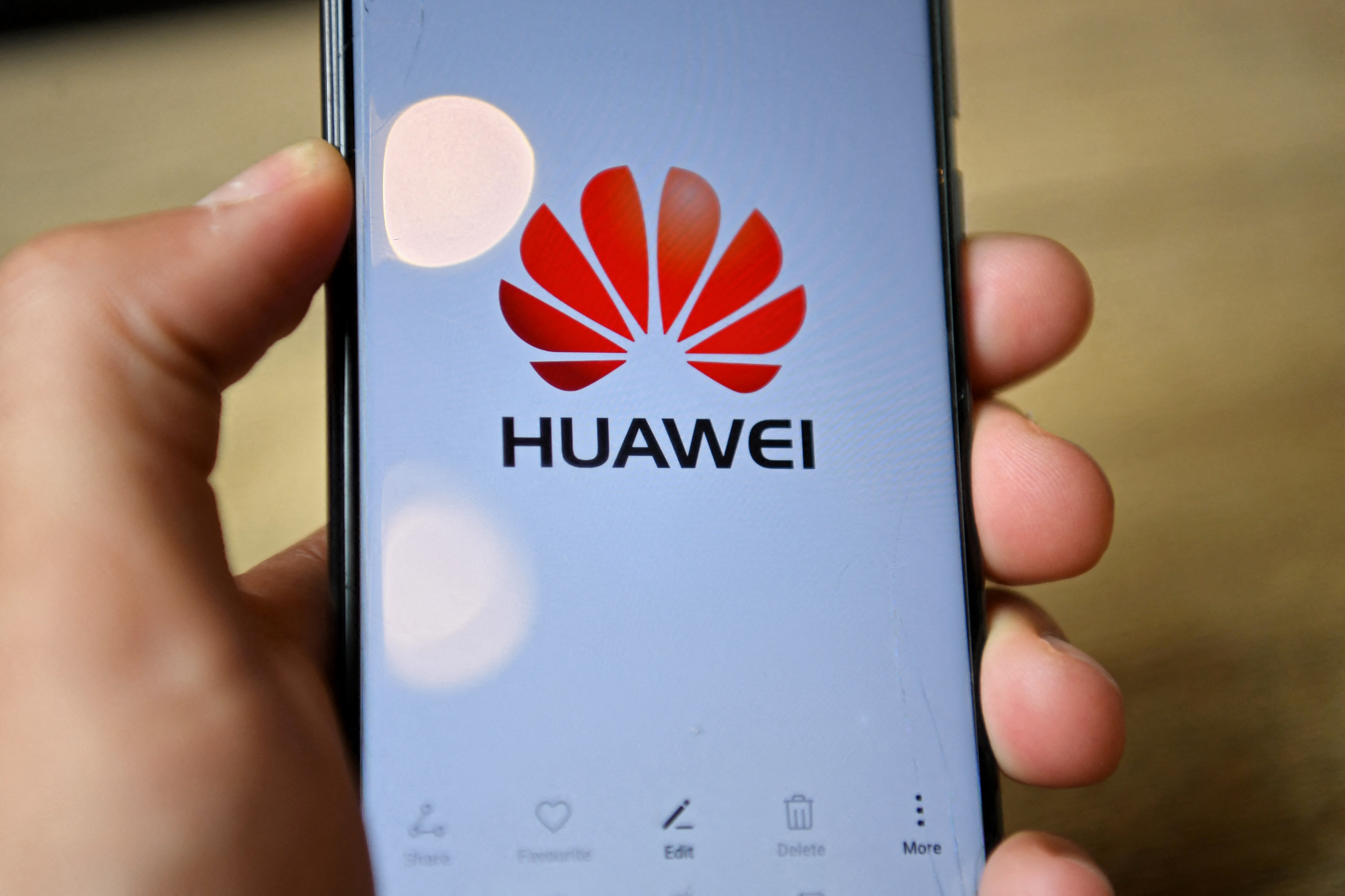 (FILES) The logo of Chinese company Huawei is seen on the screen of a Huawei mobile phone held in the photographer's hand in London on July 14, 2020.