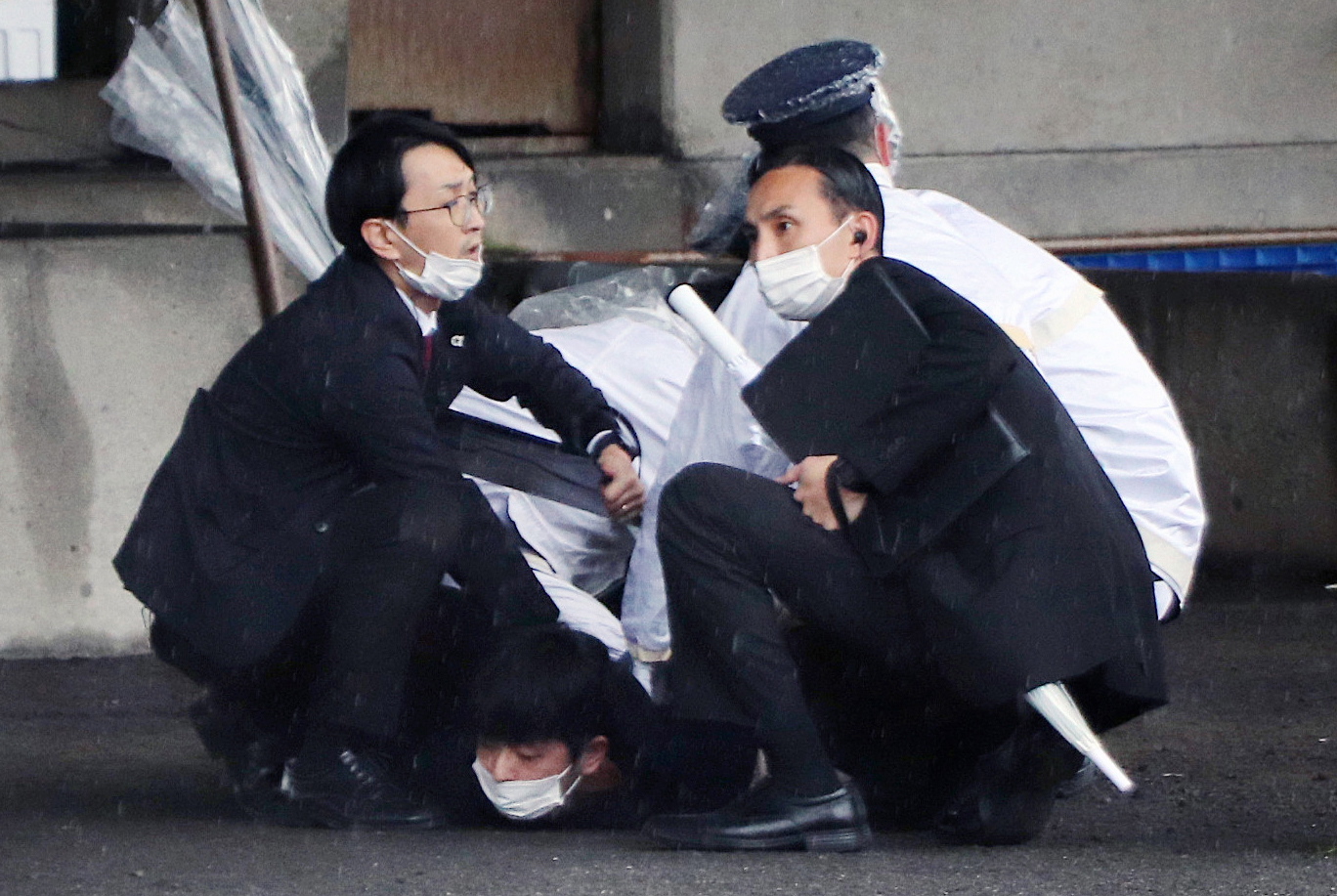 -FOTODELDÍA- Wakayama (Japón), 14/04/2023.- Agentes de Policía detienen a un individuo por el lanzamiento de un cilindro explosivo hacia el primer ministro nipón, Fumio Kishida, un hombre de 24 años llamado Ryuji Kimura, que portaba además otro segundo explosivo. EFE/JIJI PRESS - PROHIBIDO US USO EN JAPÓN -. SOLO USO EDITORIAL