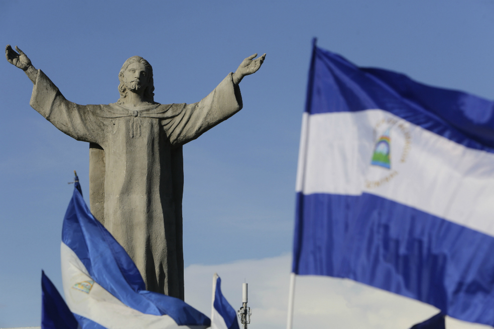 Banderas de Nicaragua ondean cerca del monumento de Cristo el rey en Managua durante protestas en contra del gobierno de Daniel Ortega.