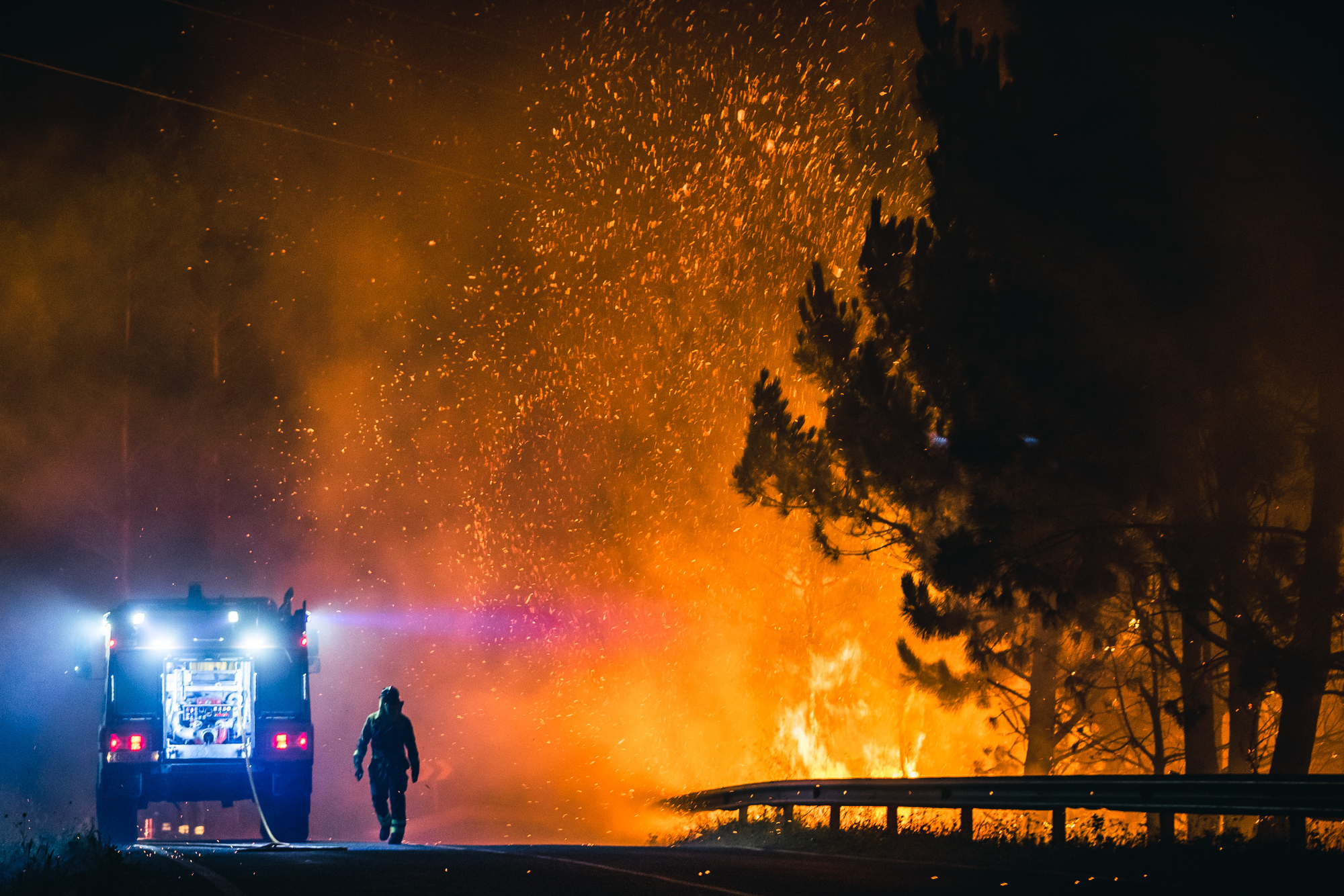 BOIRO (A CORUÑA), 06/08/2022.- Un operario de las Brigadas de Refuerzo de Incendios Forestales (BRIF) lucha contra las llamas en la madrugada de este sábado para extinguir el incendio declarado en el día anterior en la parroquia de Cures, Boiro, A Coruña, y que esta pasada noche alcanzó el monte de A Curota. EFE/Óscar Corral