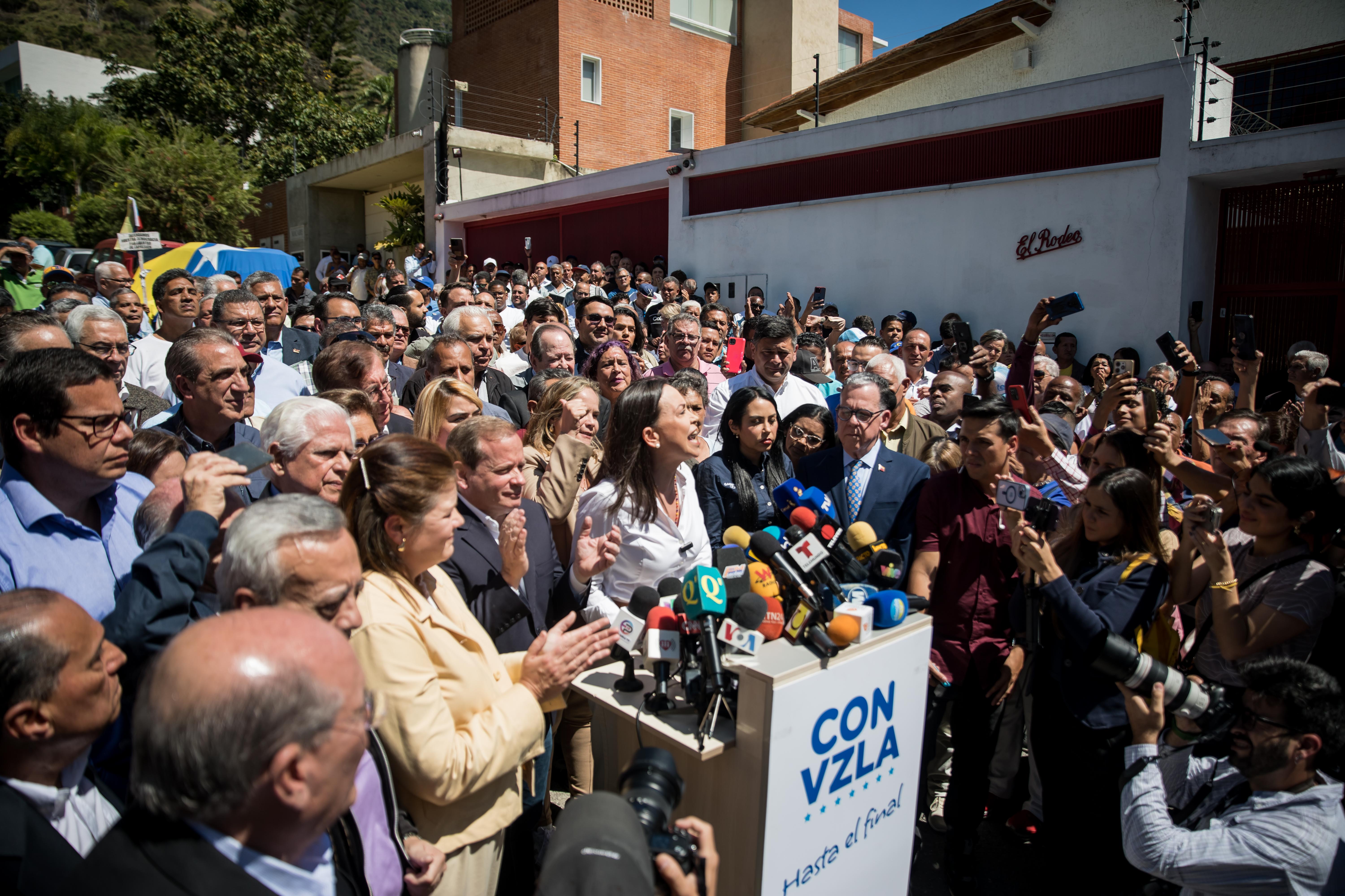AME3081. CARACAS (VENEZUELA), 29/01/2024.- La líder opositora venezolana María Corina Machado (c) ofrece hoy declaraciones a la prensa durante un acto de calle, en Caracas (Venezuela). Machado aseguró este lunes que competirá en las presidenciales de este año, como candidata del mayor bloque antichavista, pese a la sentencia publicada el viernes en la que el Tribunal Supremo de Jsuticia (TSJ) ratificó que está impedida para participar en comicios hasta 2036. EFE/ MIGUEL GUTIERREZ