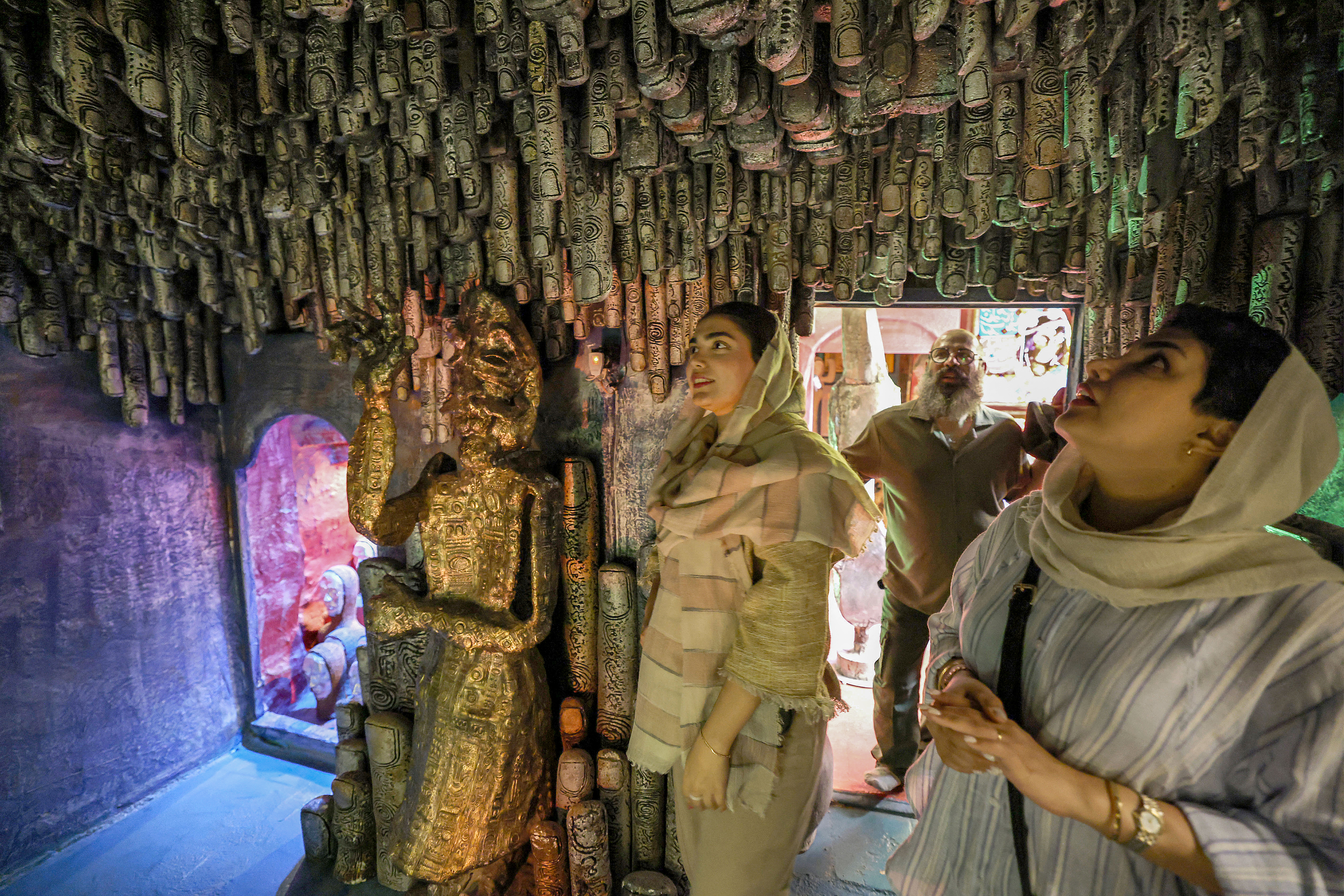 (FILES) Visitors check artwork inside the workshop of Adel Yazdi, an Iranian artist who has transformed an alley in one of the old neighbourhoods of Shiraz into an open air permanent art gallery, on May 14, 2024.