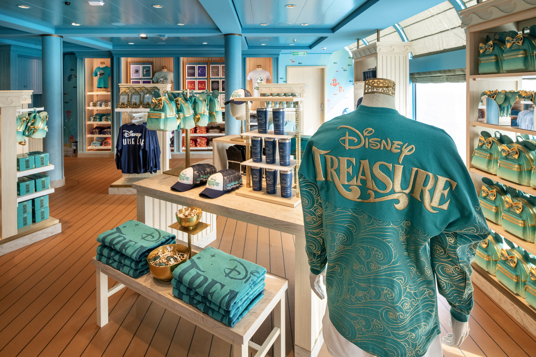 Desde ropa de baño y toallas hasta camisetas con gráficos y más, las familias pueden encontrar todo lo que necesitan para pasar un día de diversión en Dory's Forget-Me-Knots a bordo del Disney Treasure
