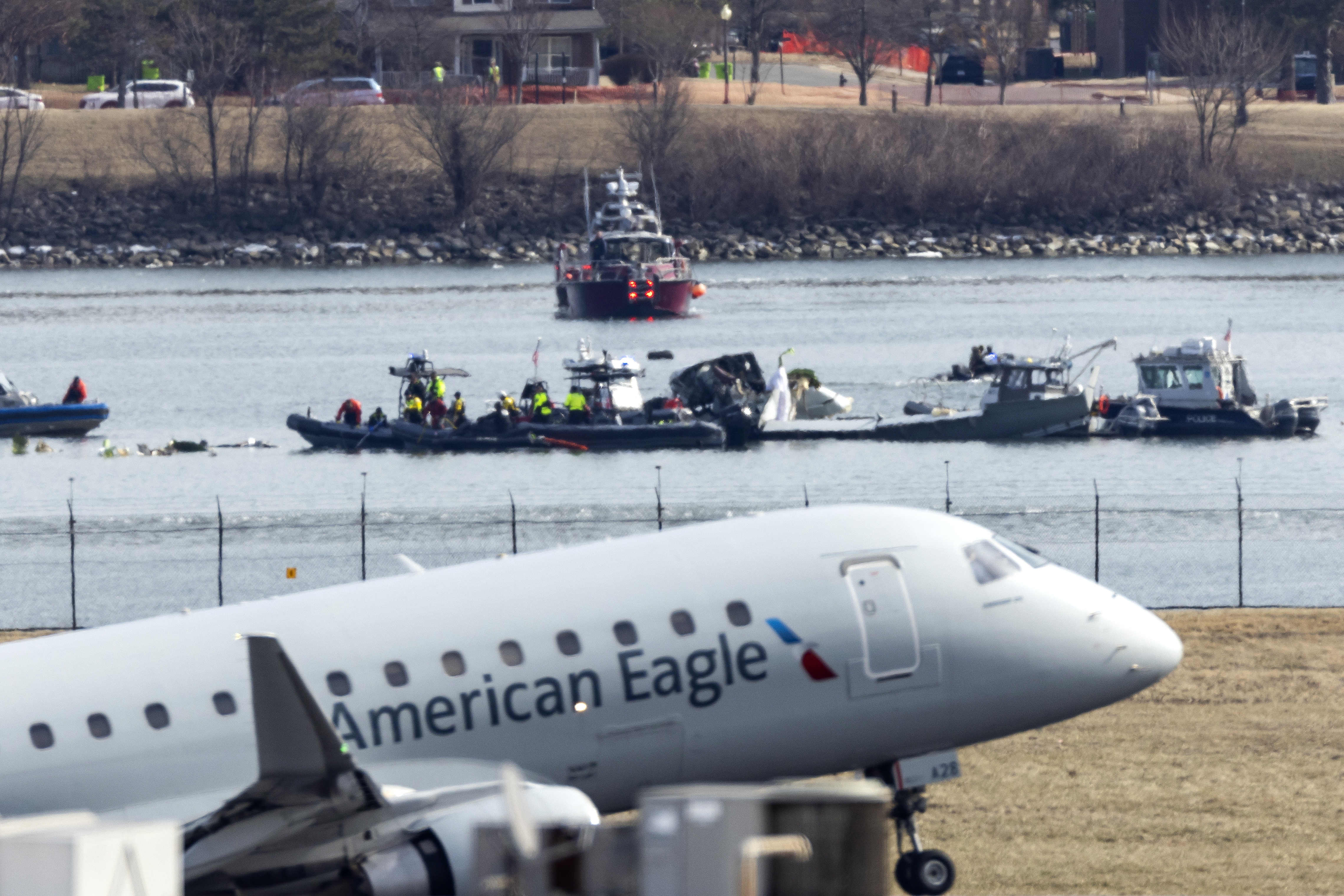 Washington (United States), 30/01/2025.- An American Eagle flight takes off from Ronald Reagan Washington National Airport in front of the wreckage of a commercial airplane that collided with a military helicopter, in Arlington, Virginia, USA, 30 January 2025. DC Fire and EMS Chief John Donnelly said no survivors are expected following the collision of an American Eagle Flight, with 60 passengers and four crew members on board, with a US Army Black Hawk helicopter carrying three US service members late on 29 January, over the Potomac River near Reagan Washington National Airport. EFE/EPA/JIM LO SCALZO