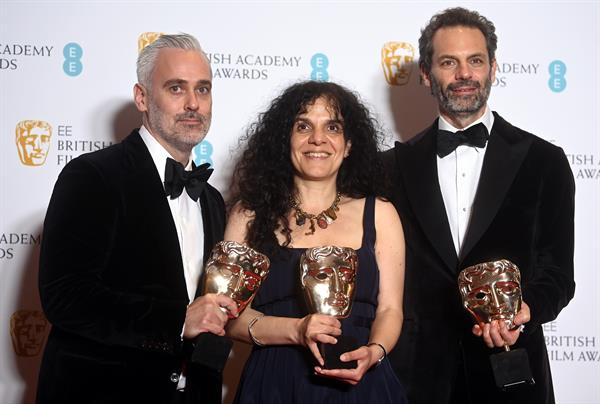Iain Canning (L), Tanya Seghatchian (C) y Emile Sherman, ganadores del premio a la Mejor Película por la película The Power of the Dog, posan en la sala de prensa durante la 75ª edición de los premios BAFTA en el Royal Albert Hall de Londres.