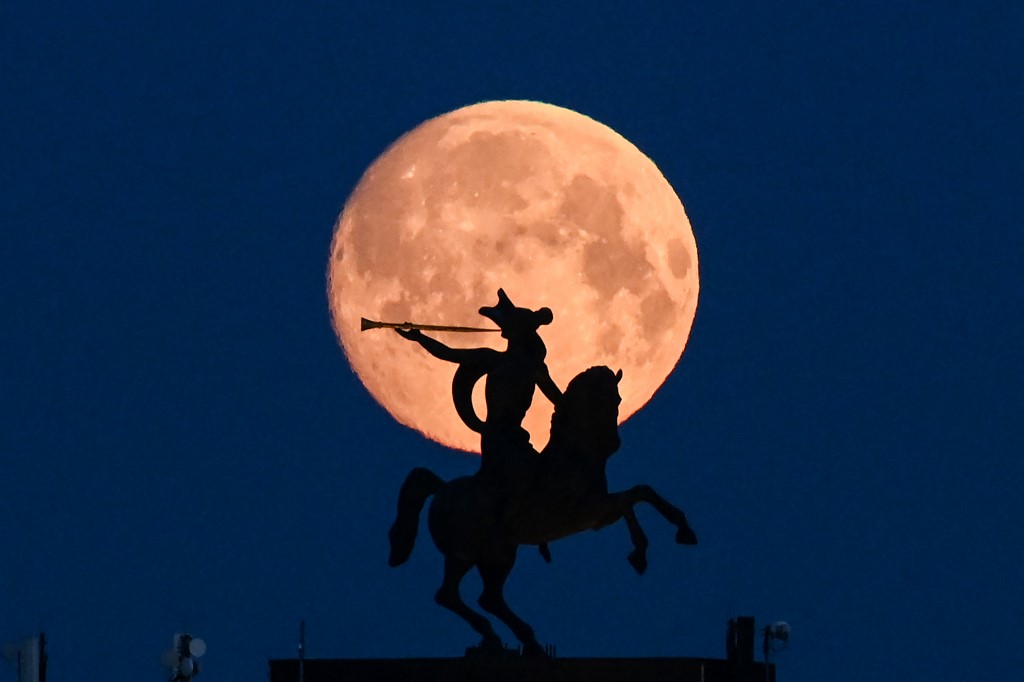 ⠀The full moon is pictured behind sculpture atop Museum of the Great Patriotic War (also known as the Victory Museum ) - the largest museum of military history in Russia with the biggest collection of World War II military items in Moscow early on April 26, 2021. (Photo by Kirill KUDRYAVTSEV / AFP)